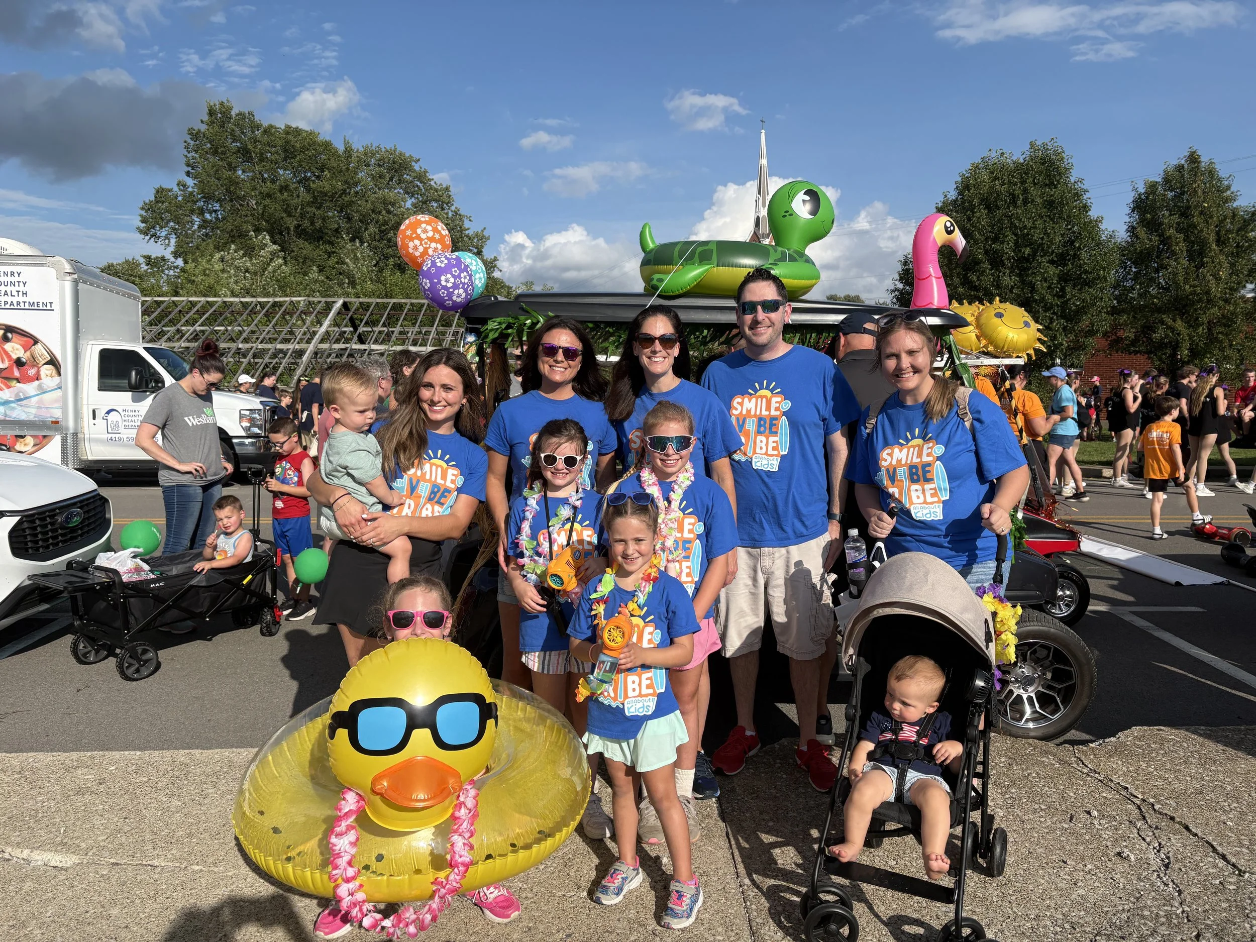All About Kids Pediatric Dentistry decorated golf cart float with tropical theme rolling down the street during the Henry County Parade in Napoleon.