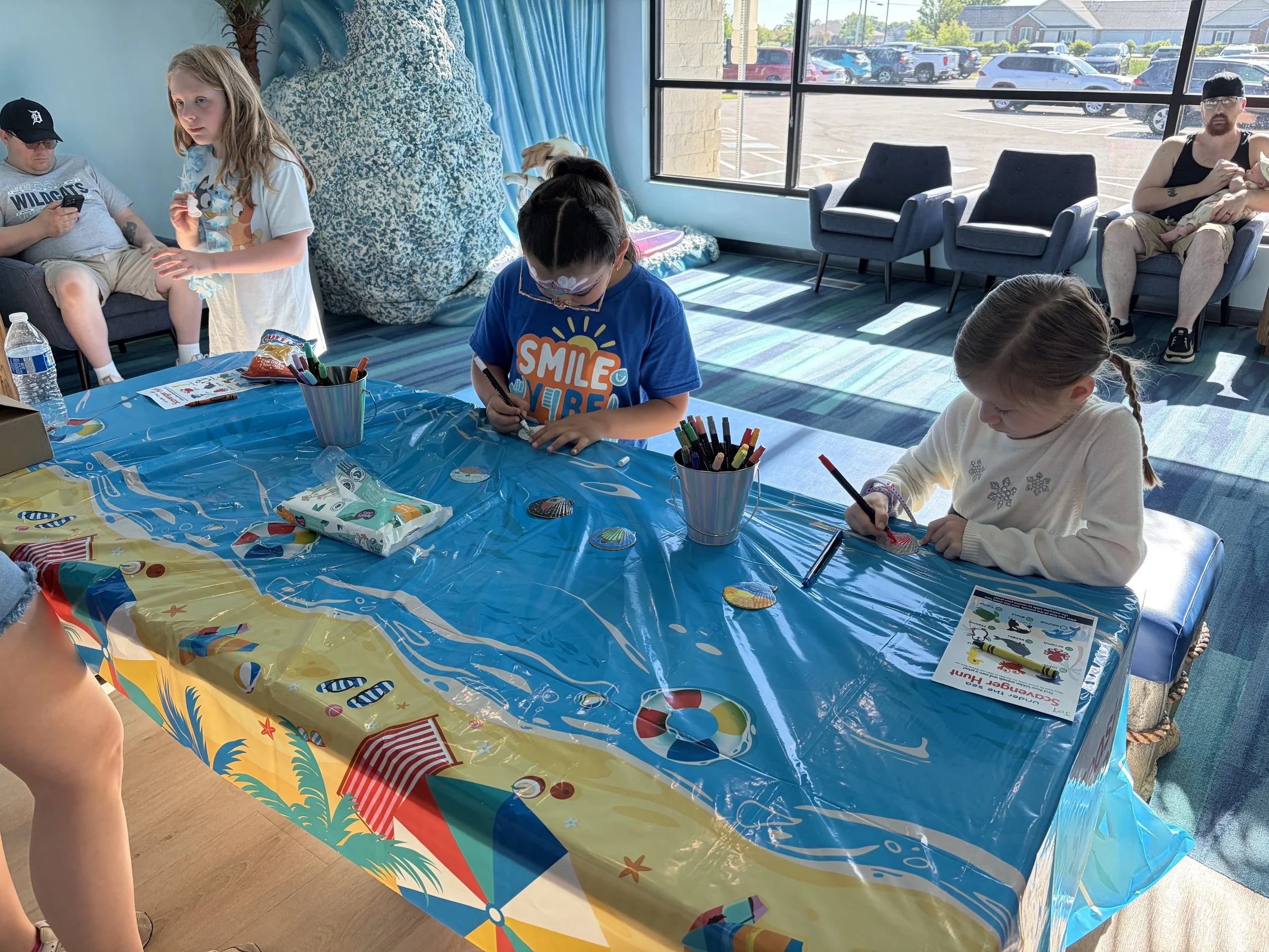 Child creating a summer craft at the All About Kids Pediatric Dentistry Family Fun Day community event.