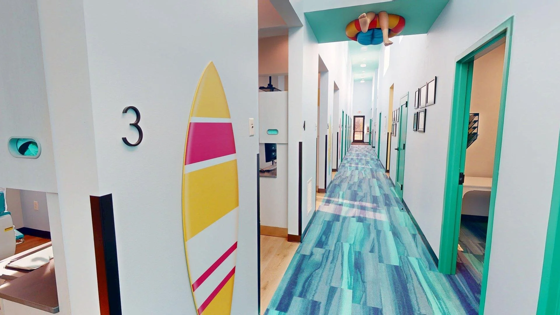 Bright hallway inside All About Kids Pediatric Dentistry in Napoleon Ohio featuring surf themed room signage and kid friendly design.