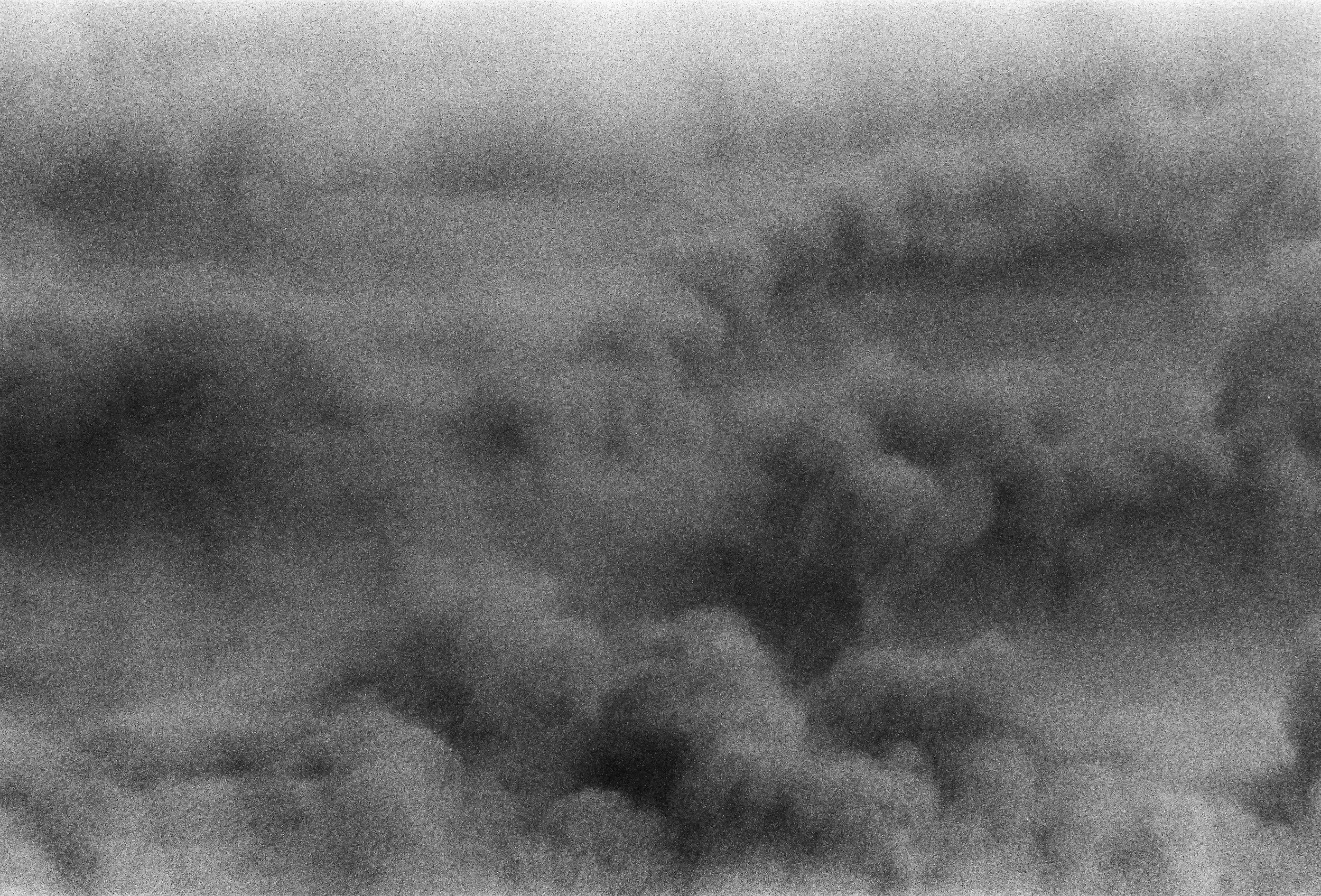 Dark, black and white of sand being kicked up underwater in Hawaii.