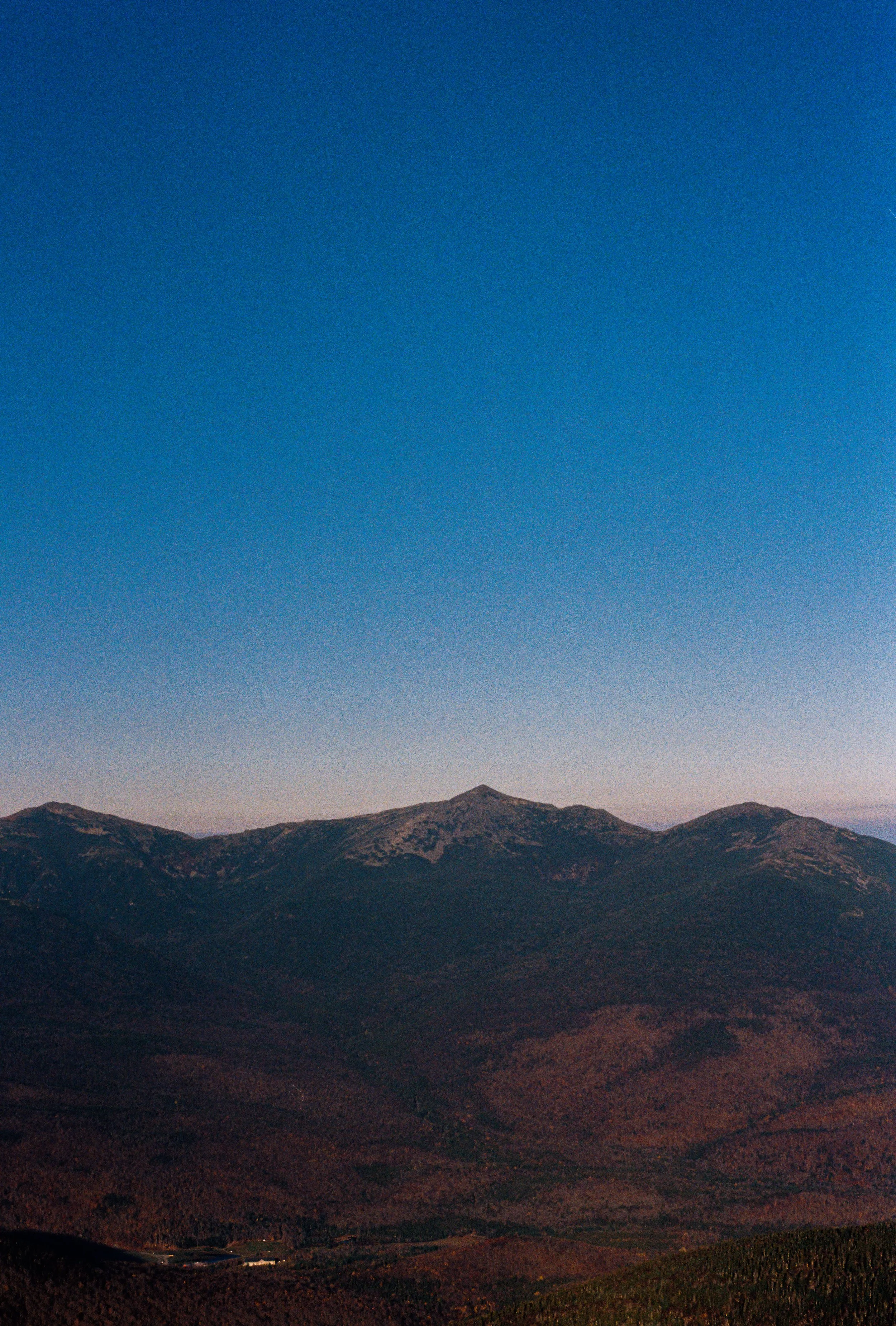A mountain range with a clear sky above at dusk or dawn.