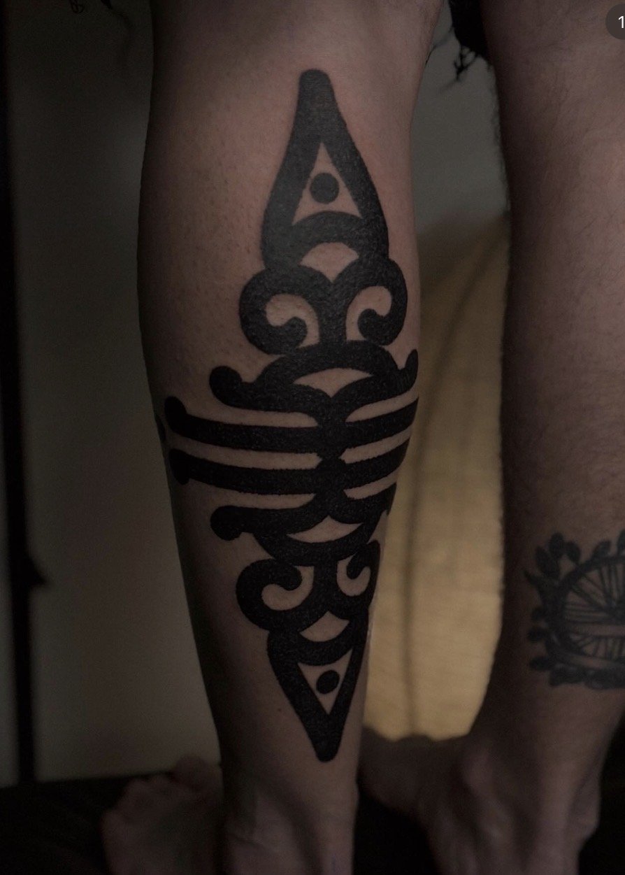 Bold black ornamental motif on the lower leg.