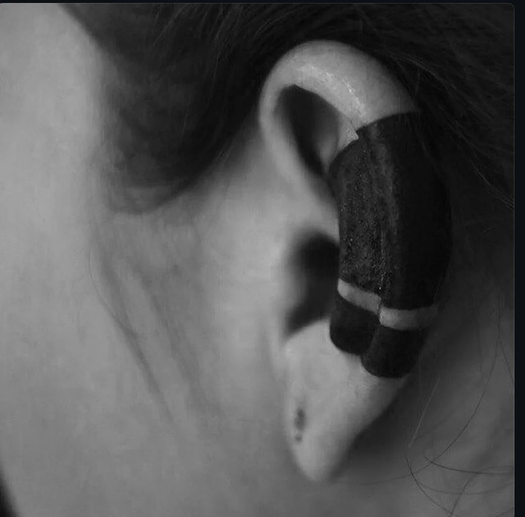 Fine black ornament around the ear.
