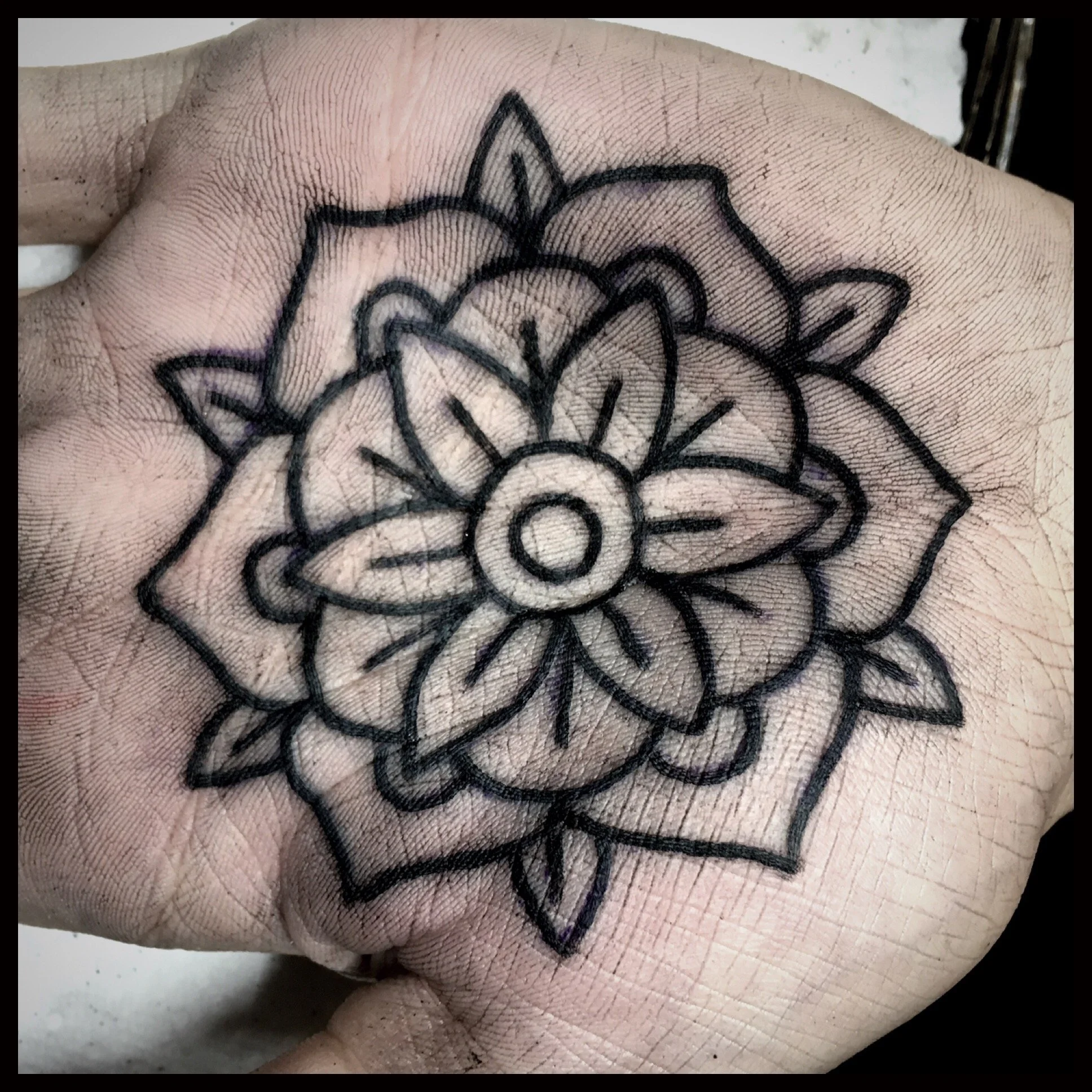 Floral ornamental tattoo on the hand.