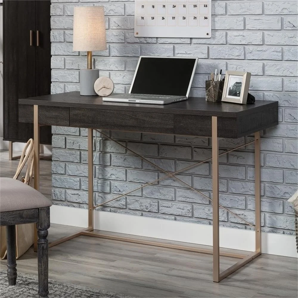 Modern home office desk with a laptop, table lamp, framed photo, and stationery, against a white brick wall.