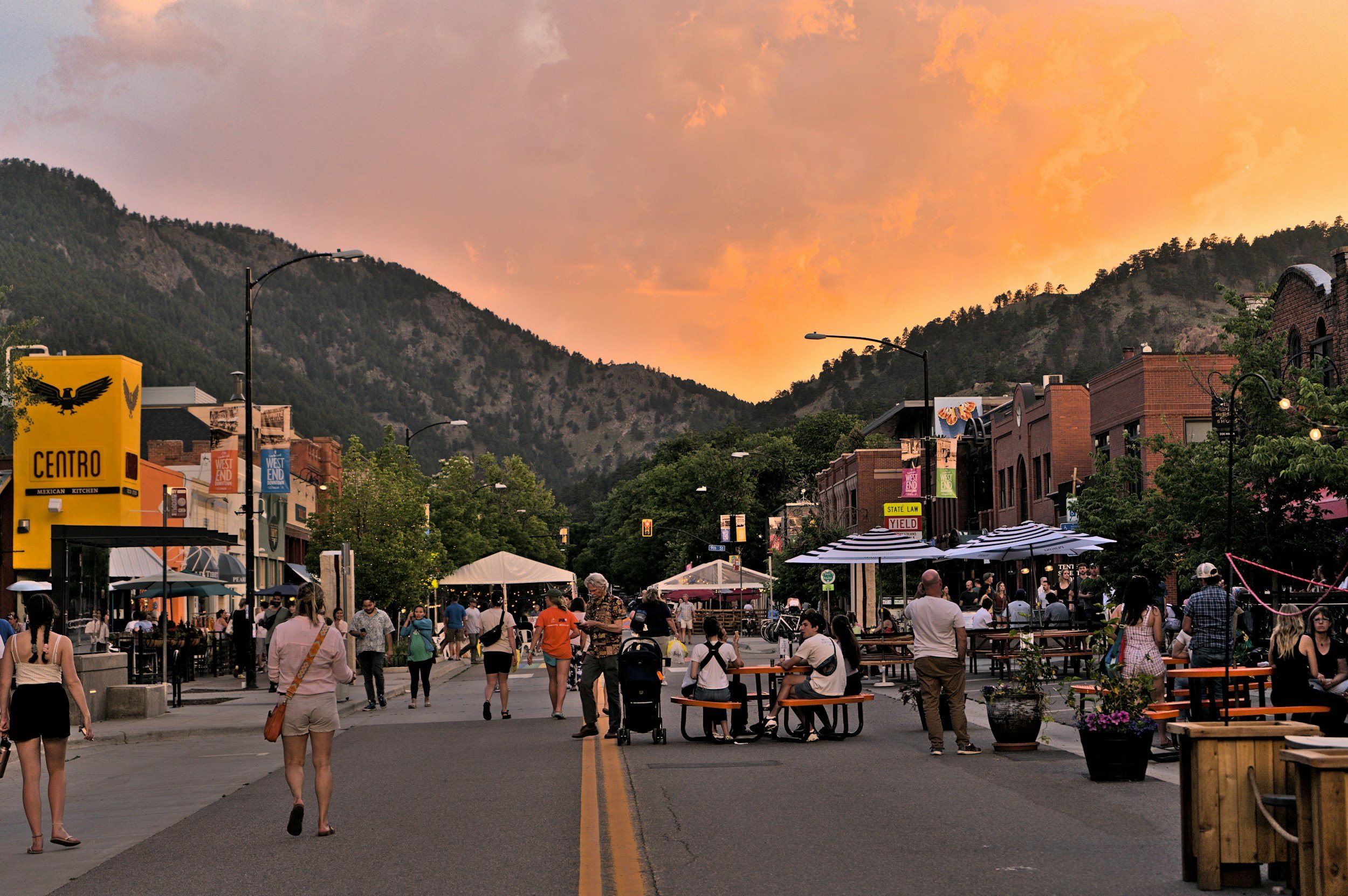 mountain town at sunset with people strolling leisurely through the street