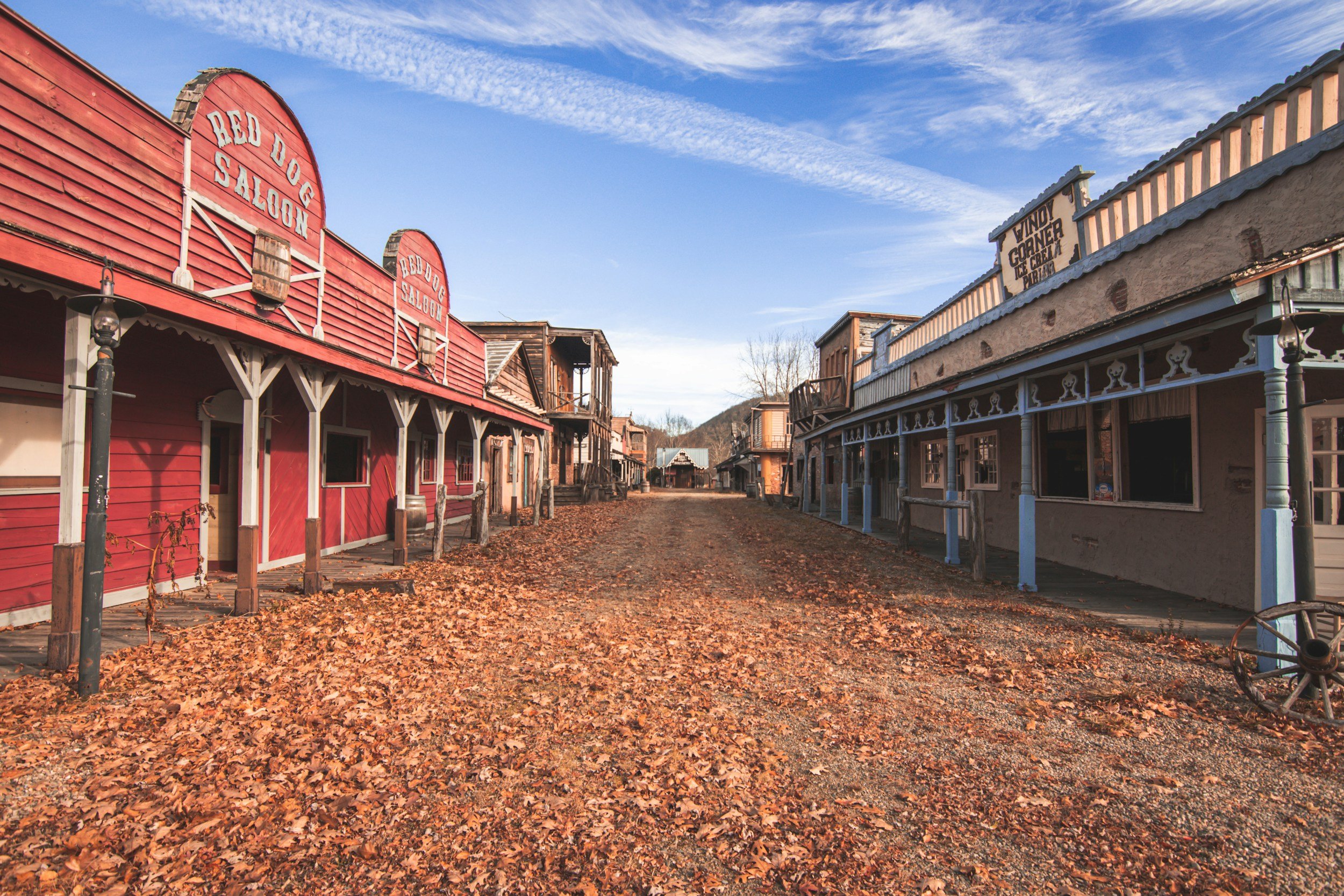 empty western town with a saloon on one side and a corner store on the other