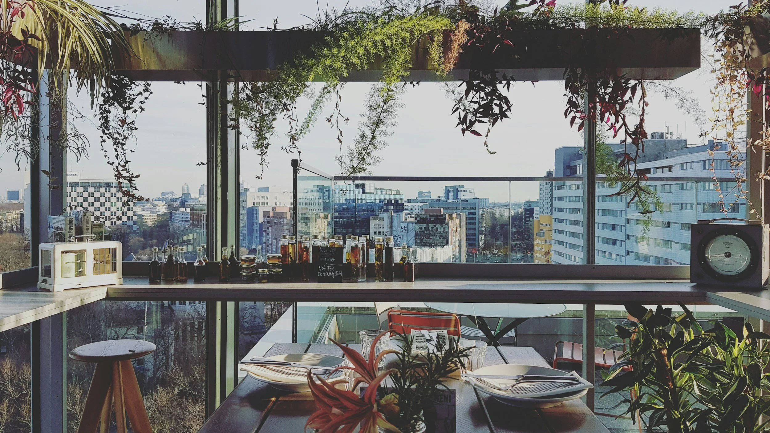 rooftop bar lined with aesthetic drinks and bottles with a cityscape background