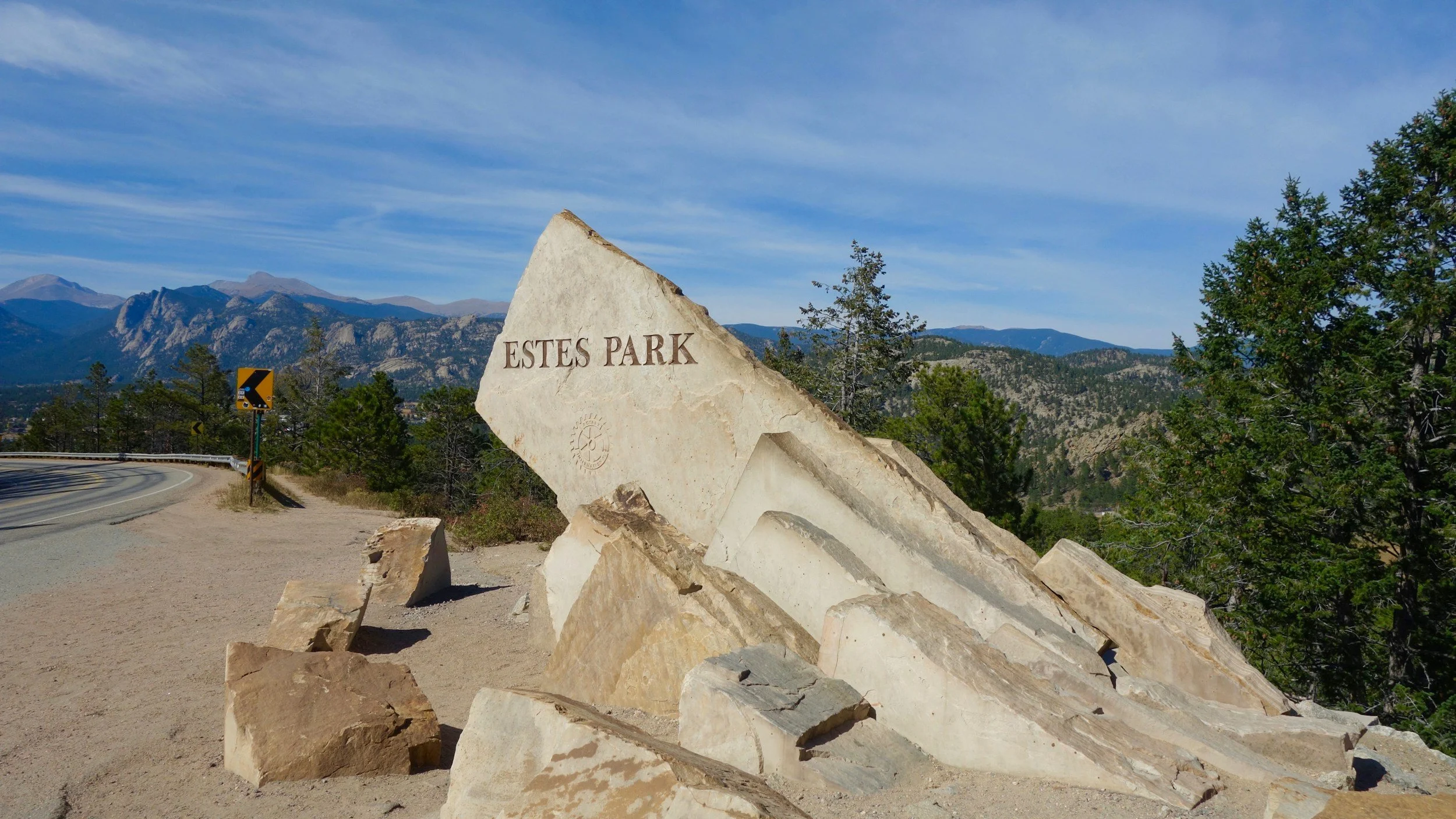 estes park sign carved into a large boulder on the side of the road