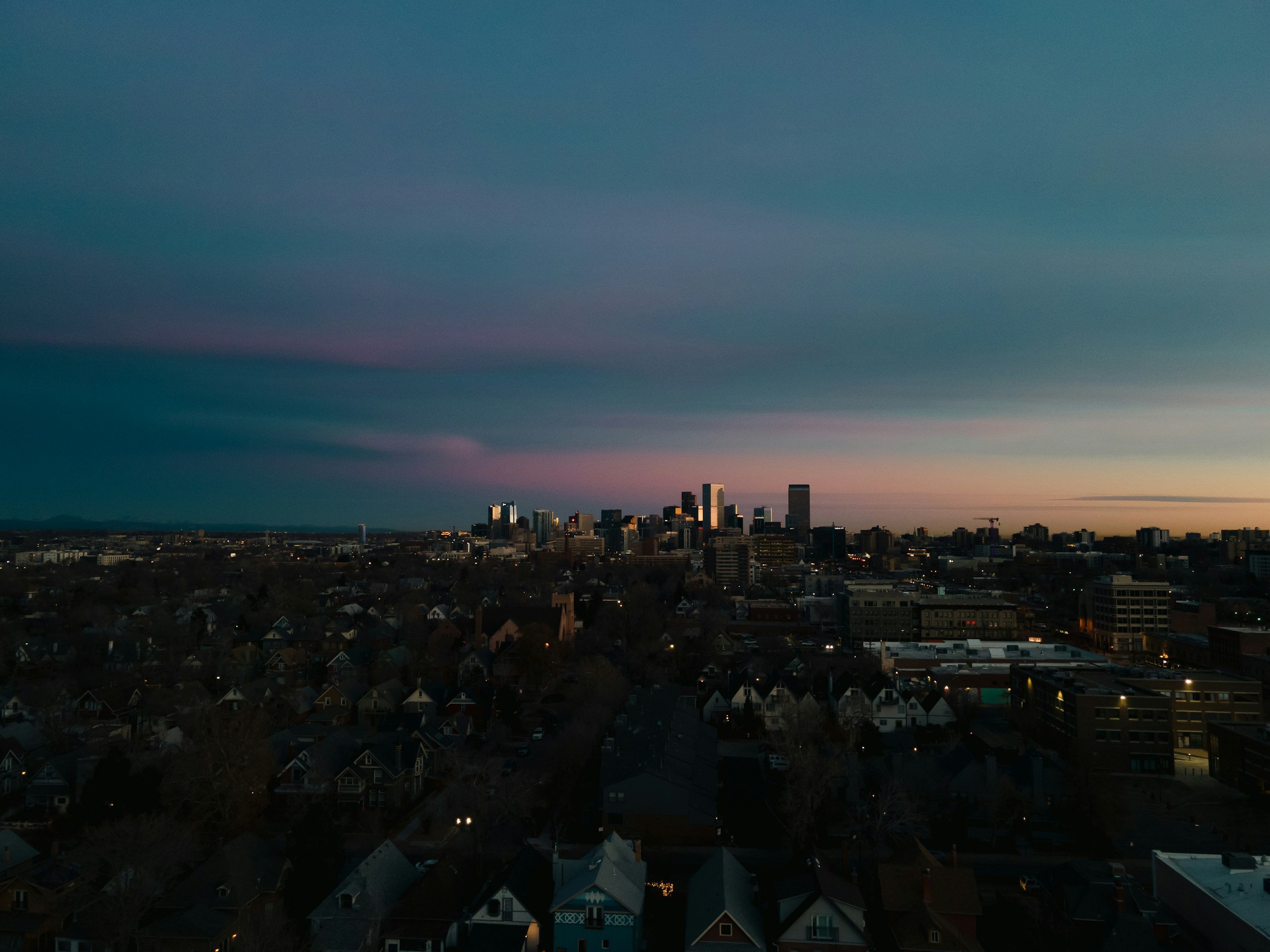 Denver skyline at night with a visible setting sun