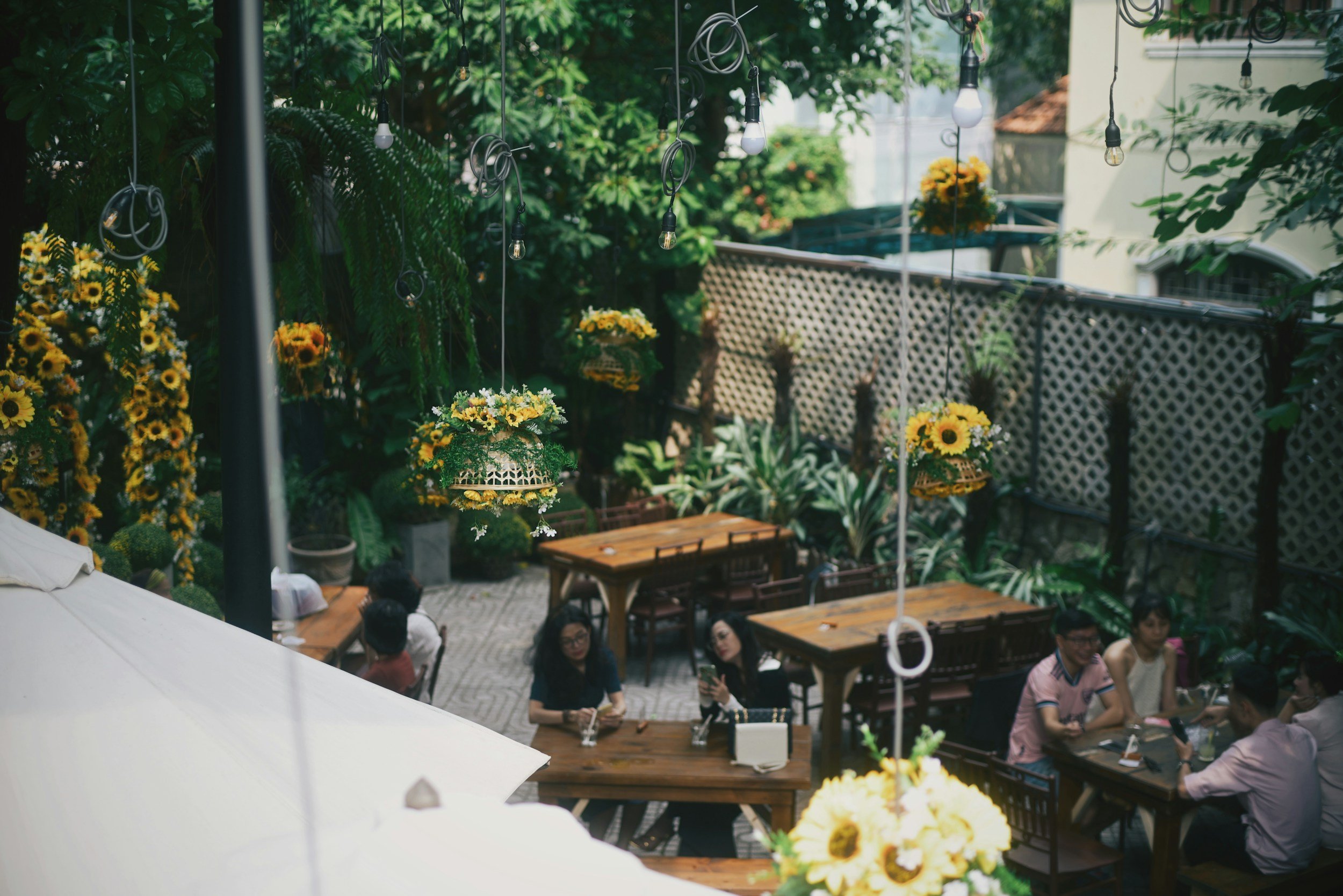 outdoor seating at a brewery with hanging flowers and cozy seating