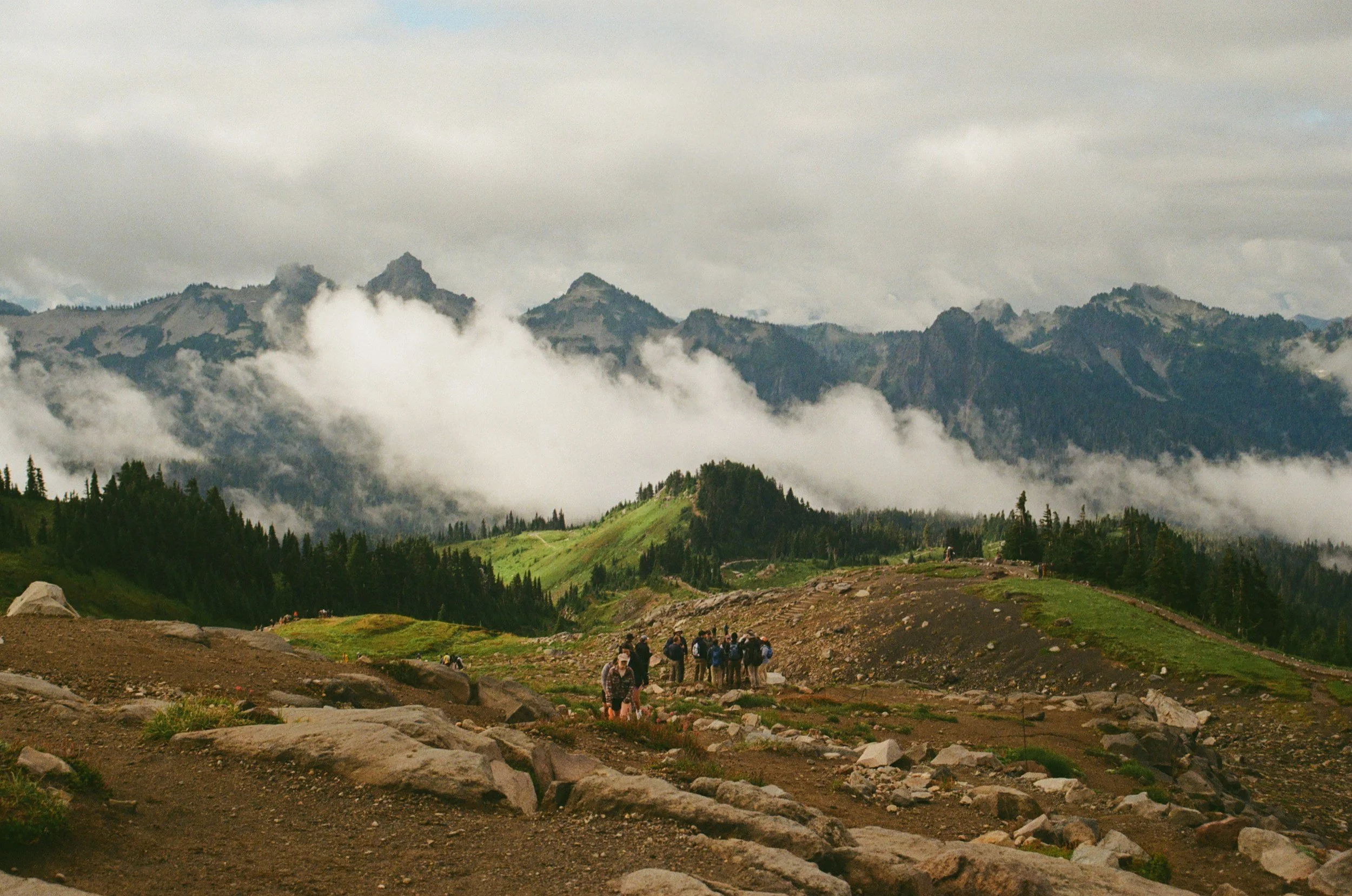 a group hiking a scenic mountain bald with a close up view of the clouds
