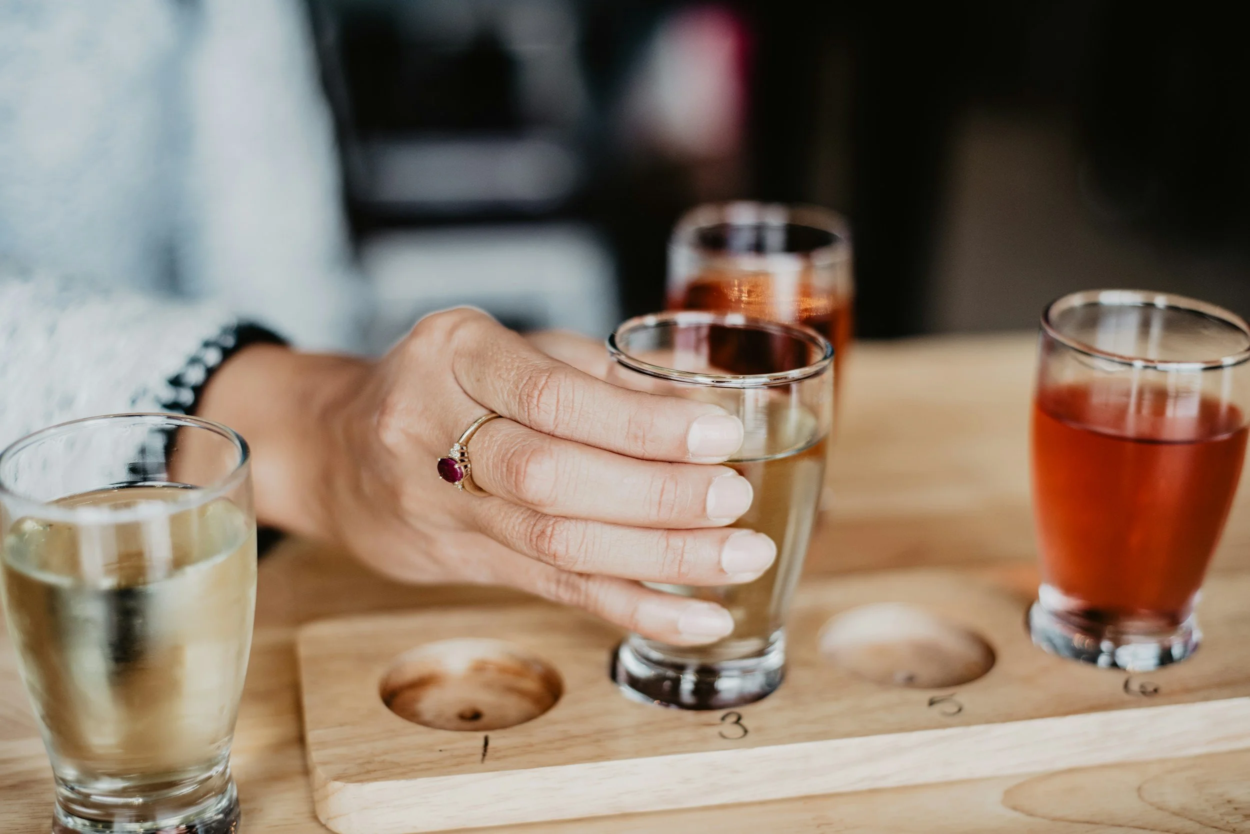 someone lifting a glass from a beer flight