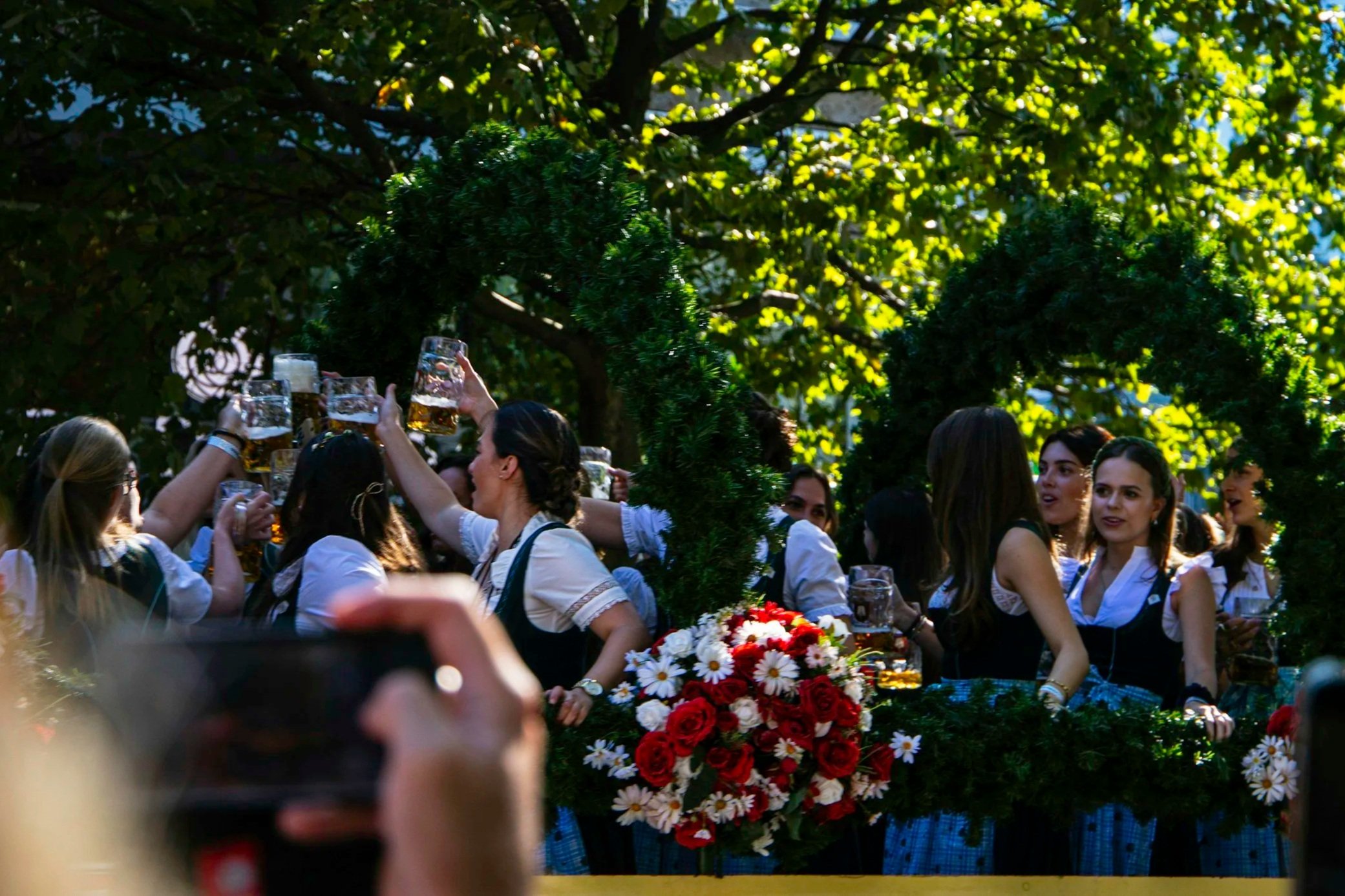 Oktoberfest celebration with people lifting large steins of beer