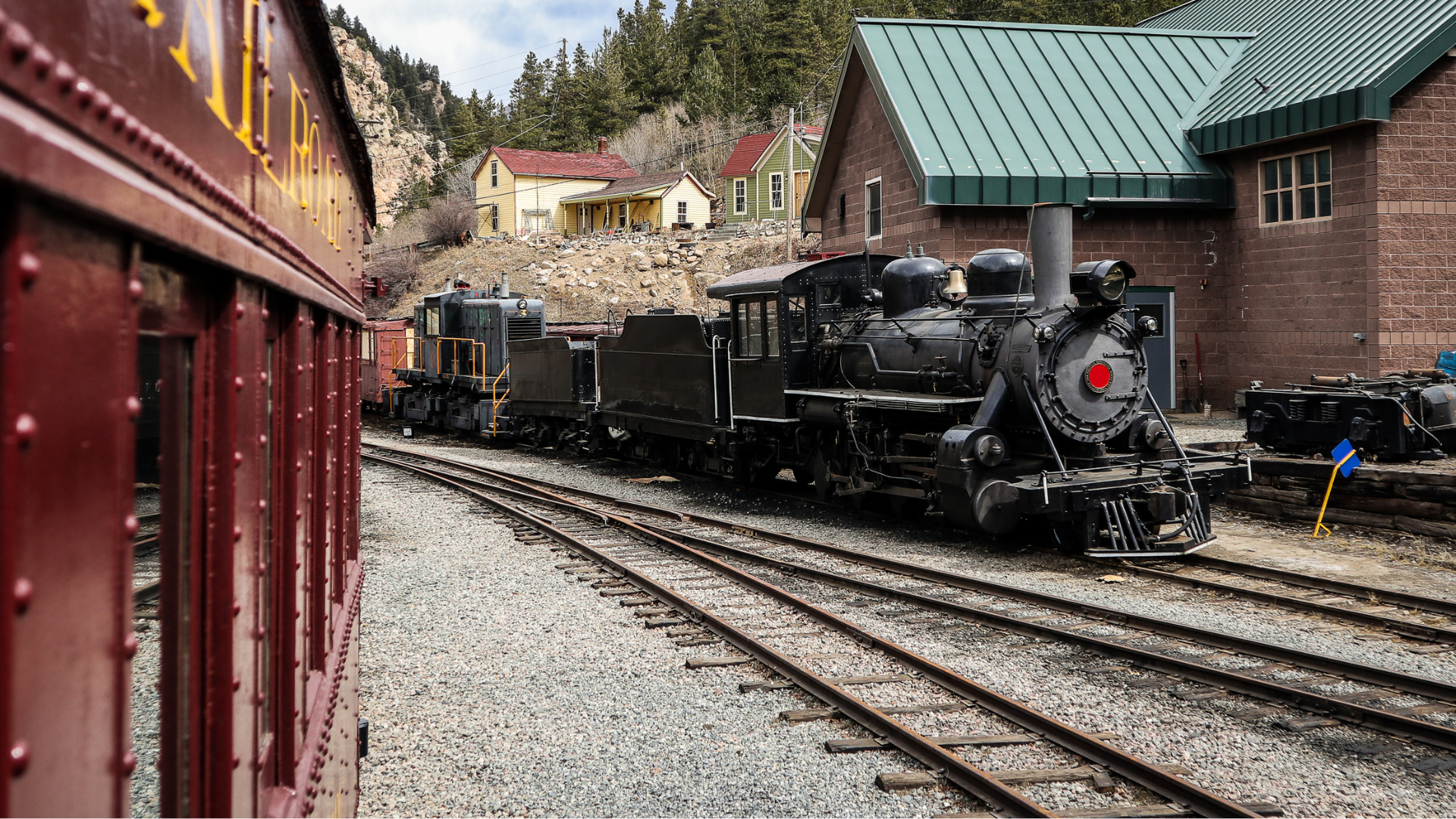 Steam locomotive of Georgetown loop railroad in Colorado, USA. Engine is parked in a depot, looking from another coach
