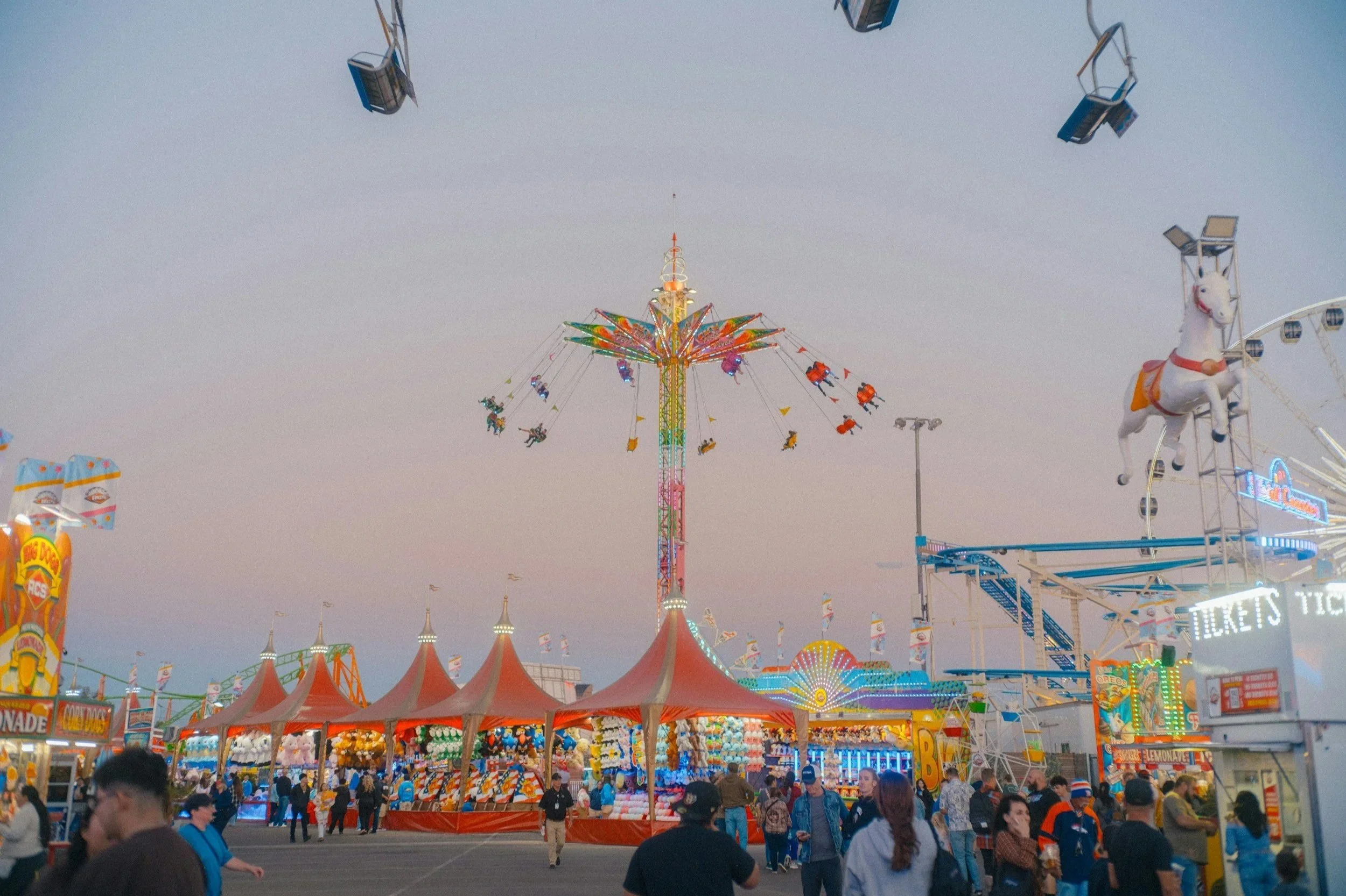 chromatic image of a carnival, showing tents with games and rides