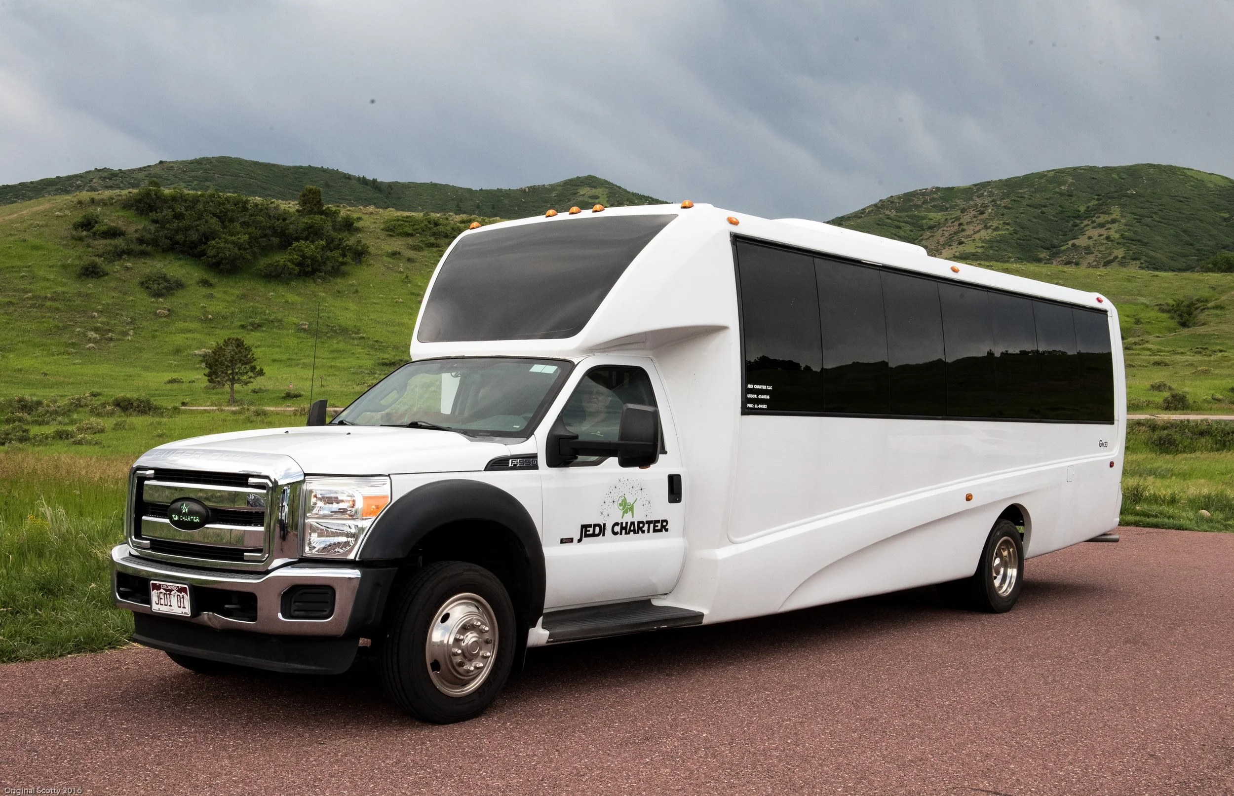 side profile of jedi charter bus with colorado mountains in the background