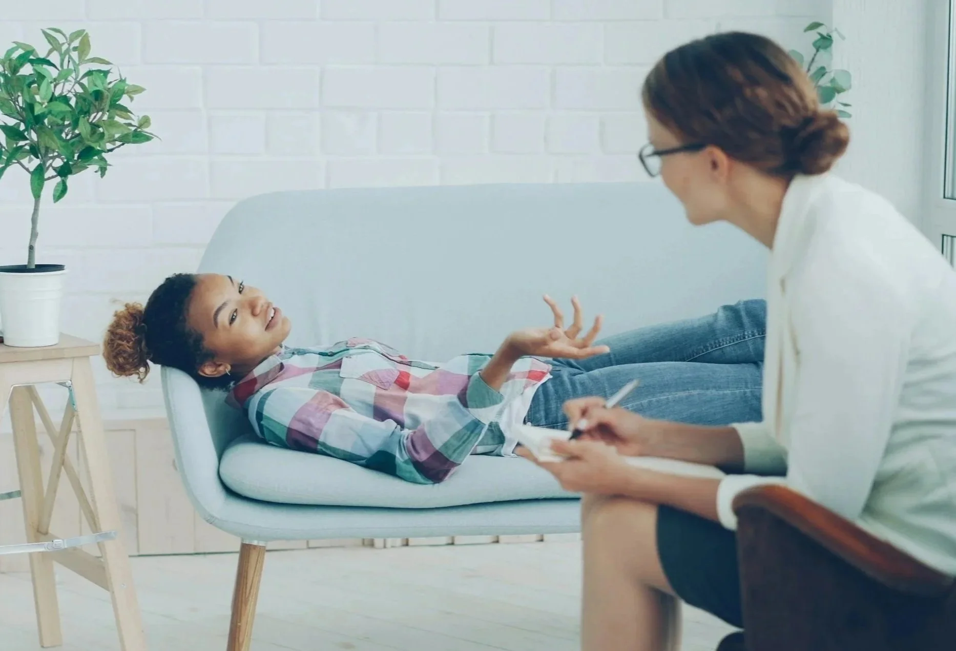 American teenage girl smiling during a therapy session with a counselor – culturally sensitive child and teen mental health care.