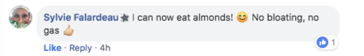 A Facebook comment by a user expressing happiness about eating almonds without bloating or gas, including a smiling emoji and thumbs-up emoji. The comment has one like.