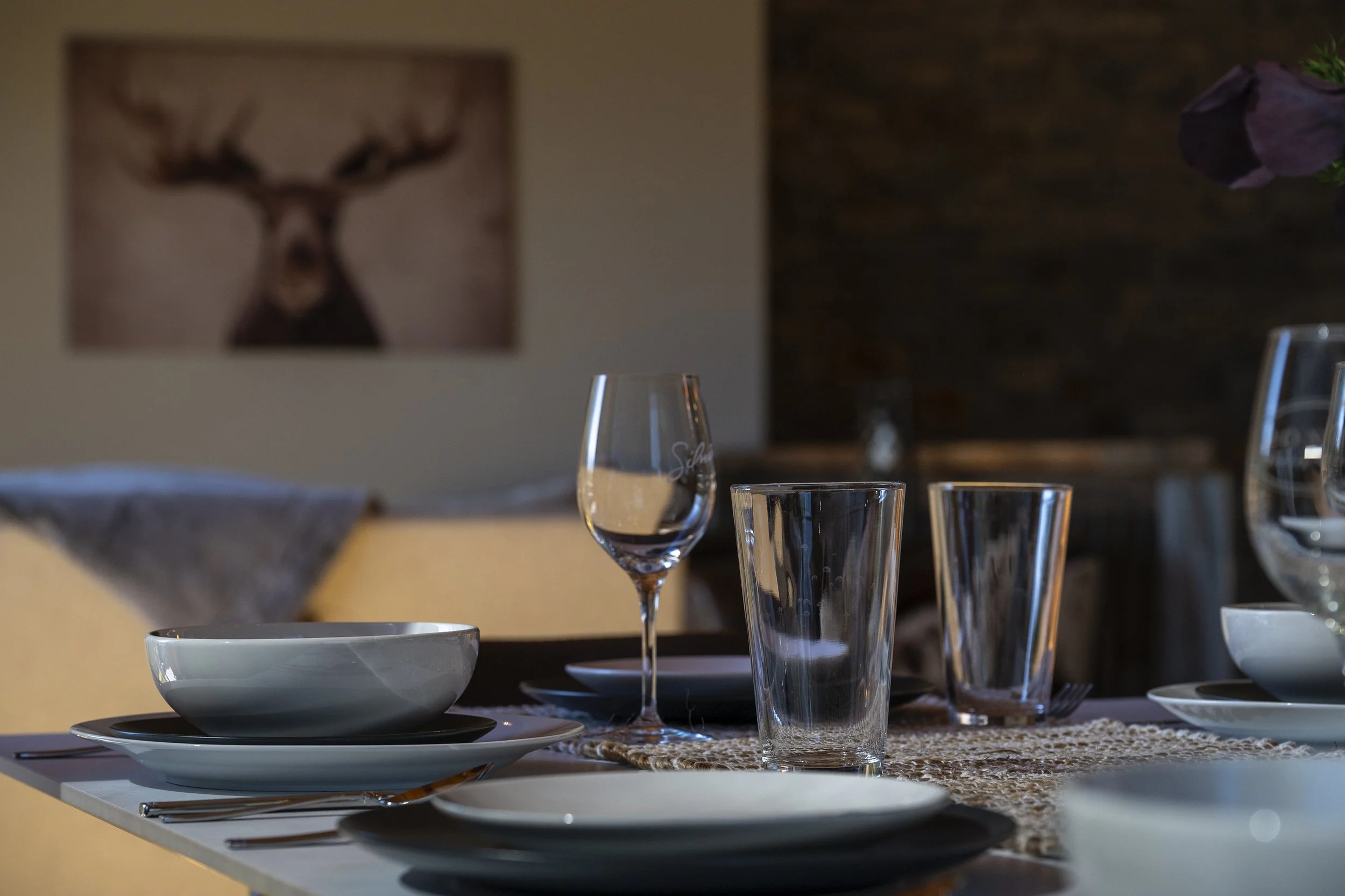 A dining table set with various glassware and dishes.