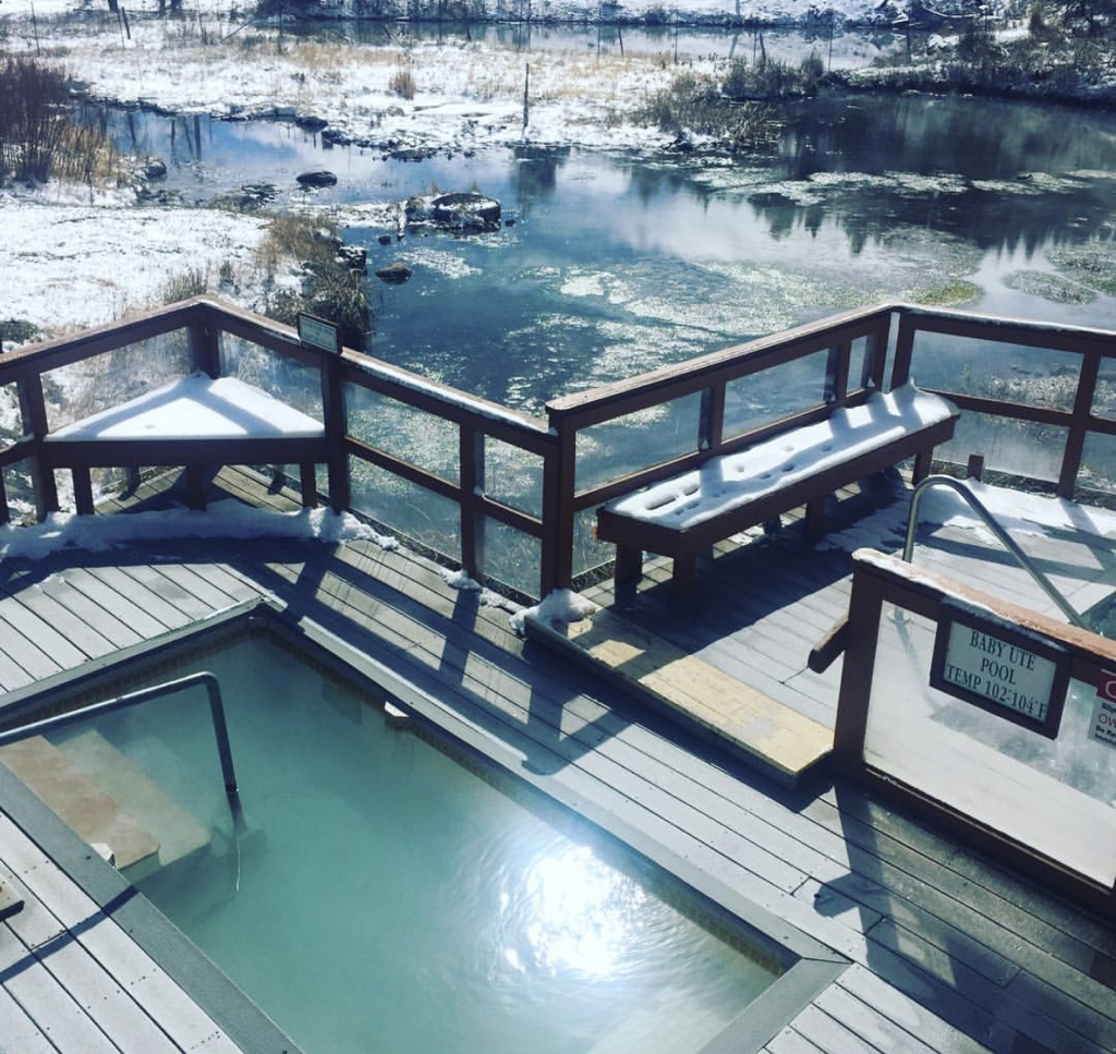 Hot springs outdoor hot tub with snow on the deck and surrounding area.