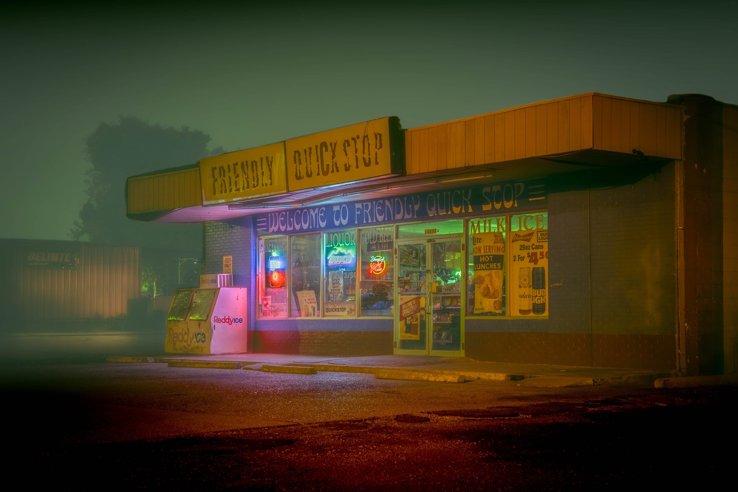 A small convenience store at night with neon lights and a sign that reads 'Friendly Quick Stop'.