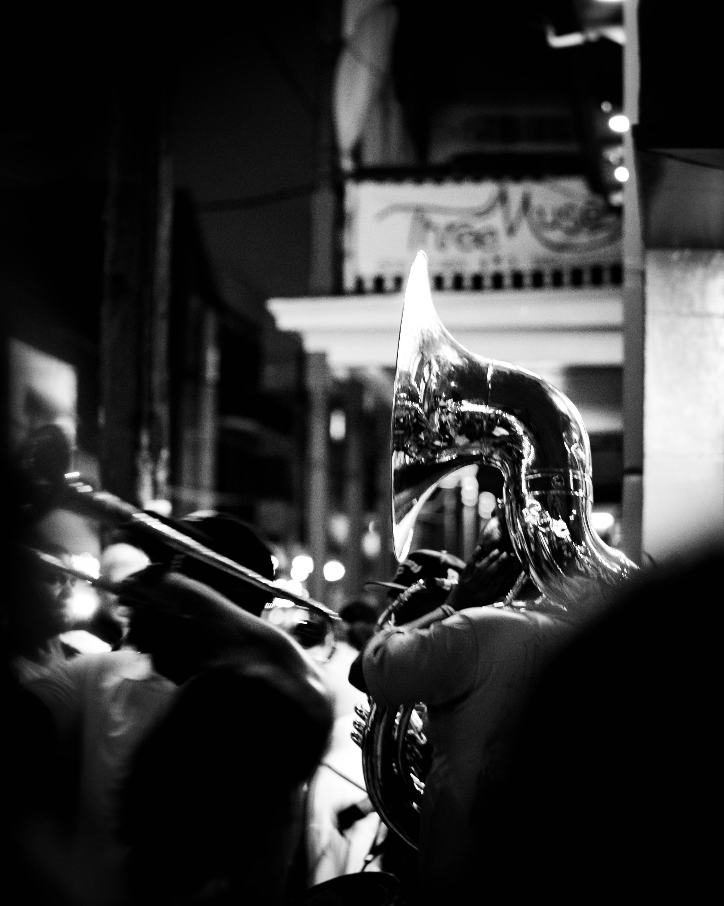A close-up of a saxophone with background shelves and boxes, captured in black and white.