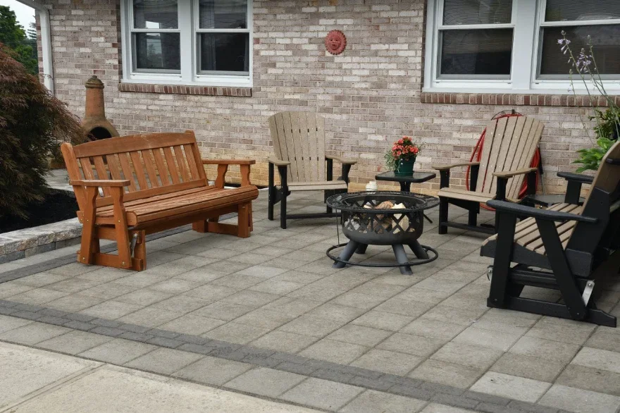 Picture of a patio behind a brick house with patio furniture and a firepit.