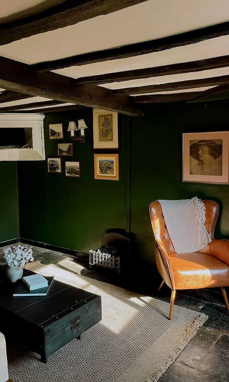 Interior of The Dun Cow pub in Hornton, featuring exposed timber beams, framed artwork, traditional seating and a relaxed lounge area.