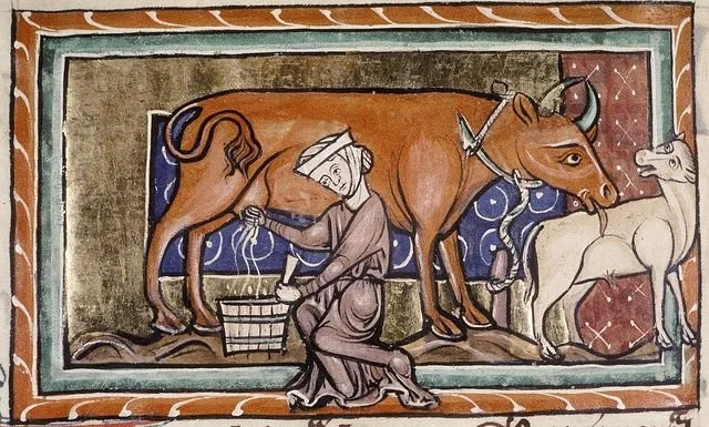 A medieval-style illustration of a woman milking a cow, with a unicorn nearby and a detailed, colorful border.