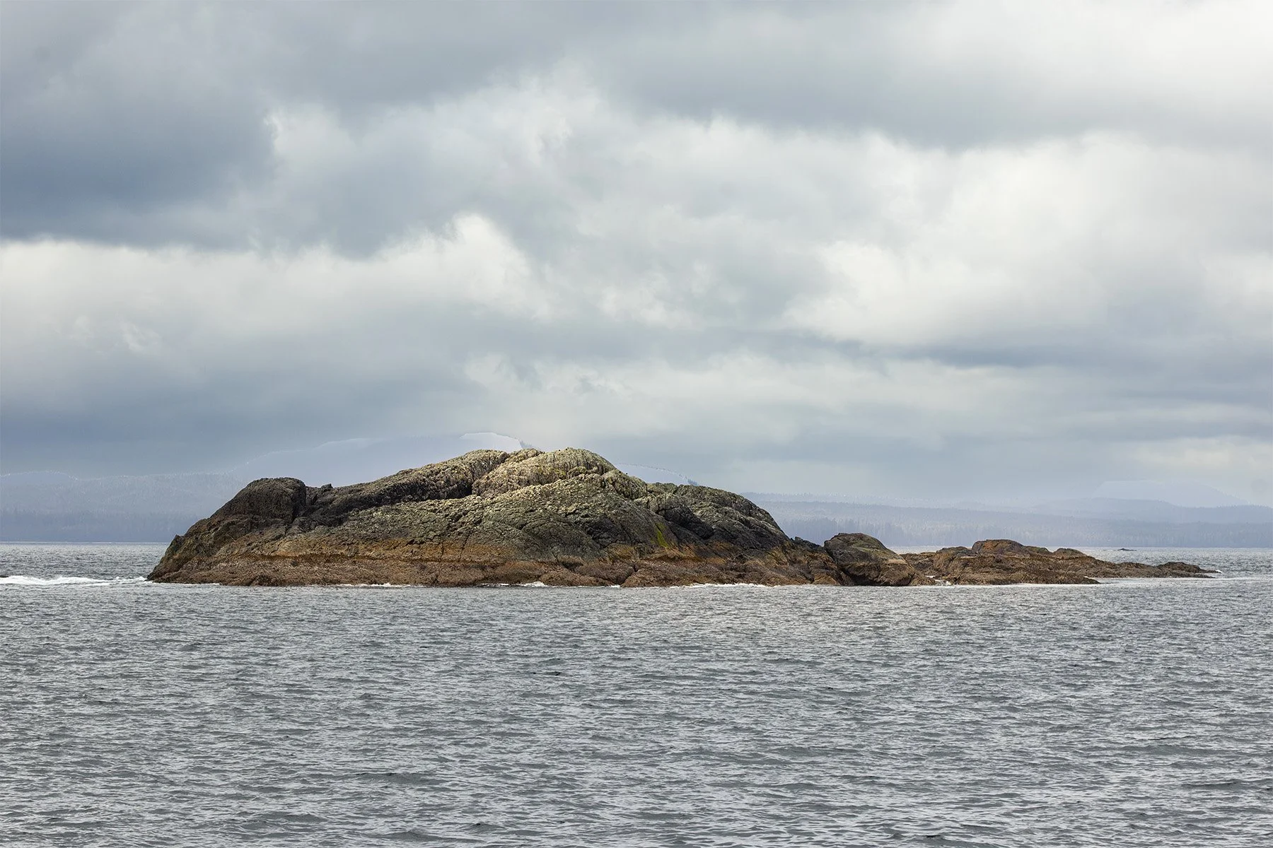 Rocky island in a cloudy seascape