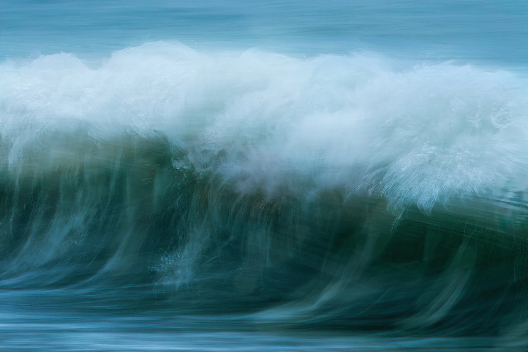 Blurry ocean wave crashing with blue and white colors