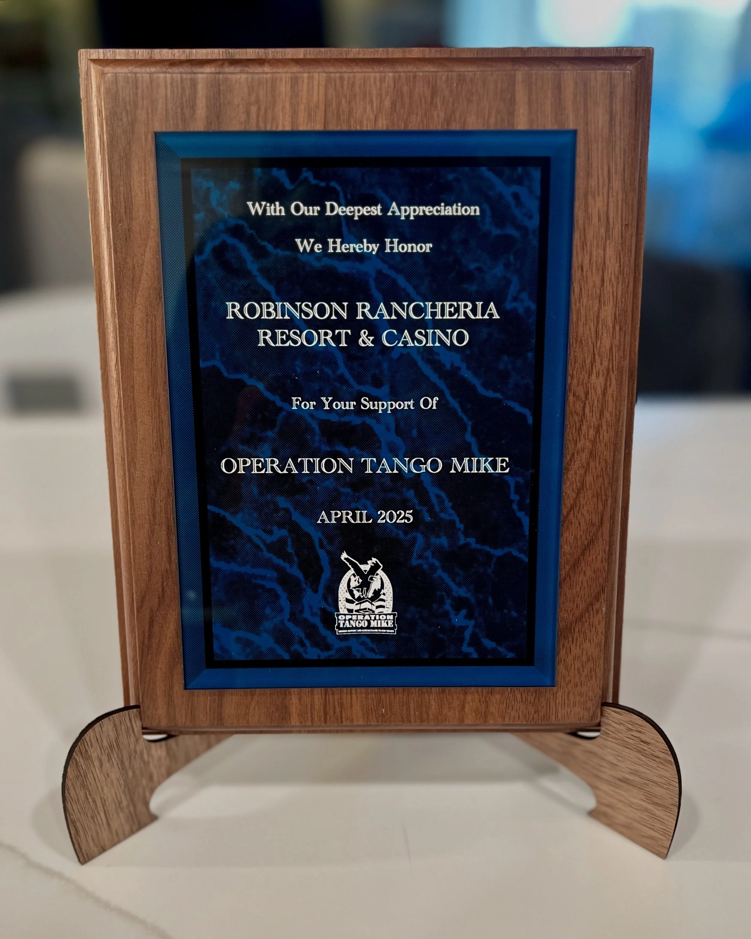 A wooden plaque honoring Robinson Rancheria Resort & Casino for supporting Operation Tango Mike in April 2025
