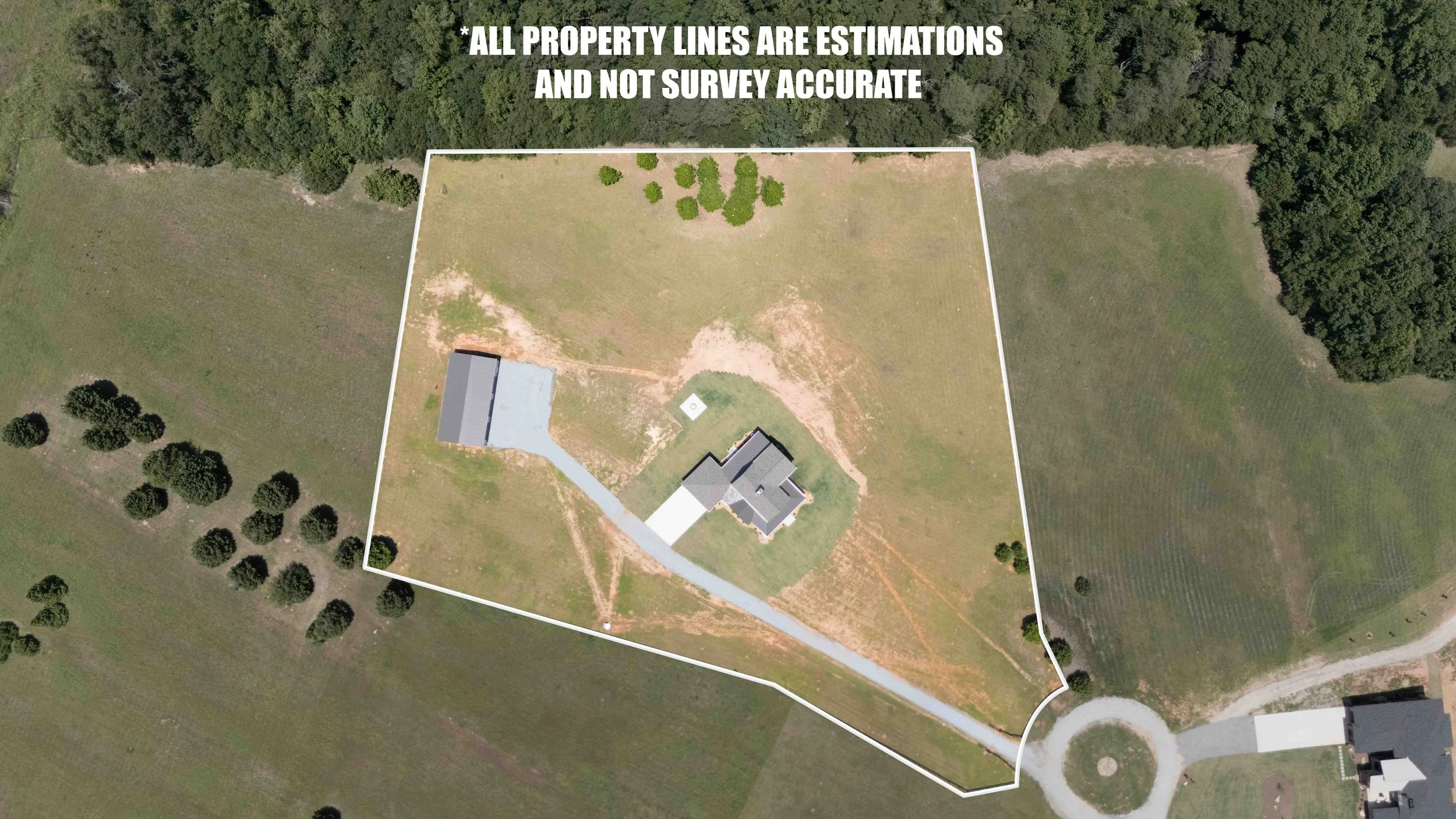 Aerial view of a property with a house, a driveway, and a fenced yard, surrounded by open fields and trees, with property line estimation marked and a note indicating that lines are not survey accurate.