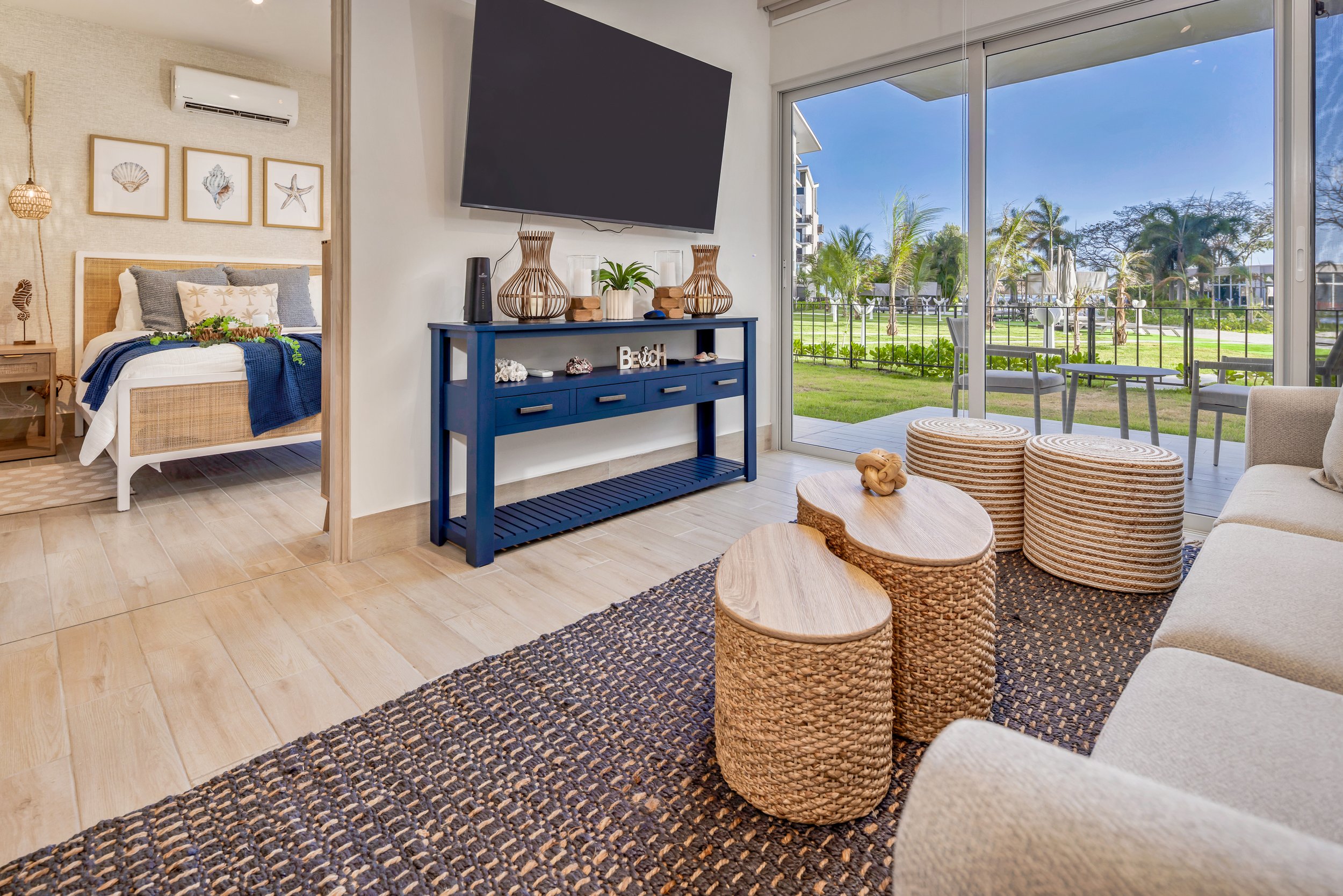 Sala acogedora en Playa Caracol, Panamá, con acceso a terraza y vista a áreas verdes.