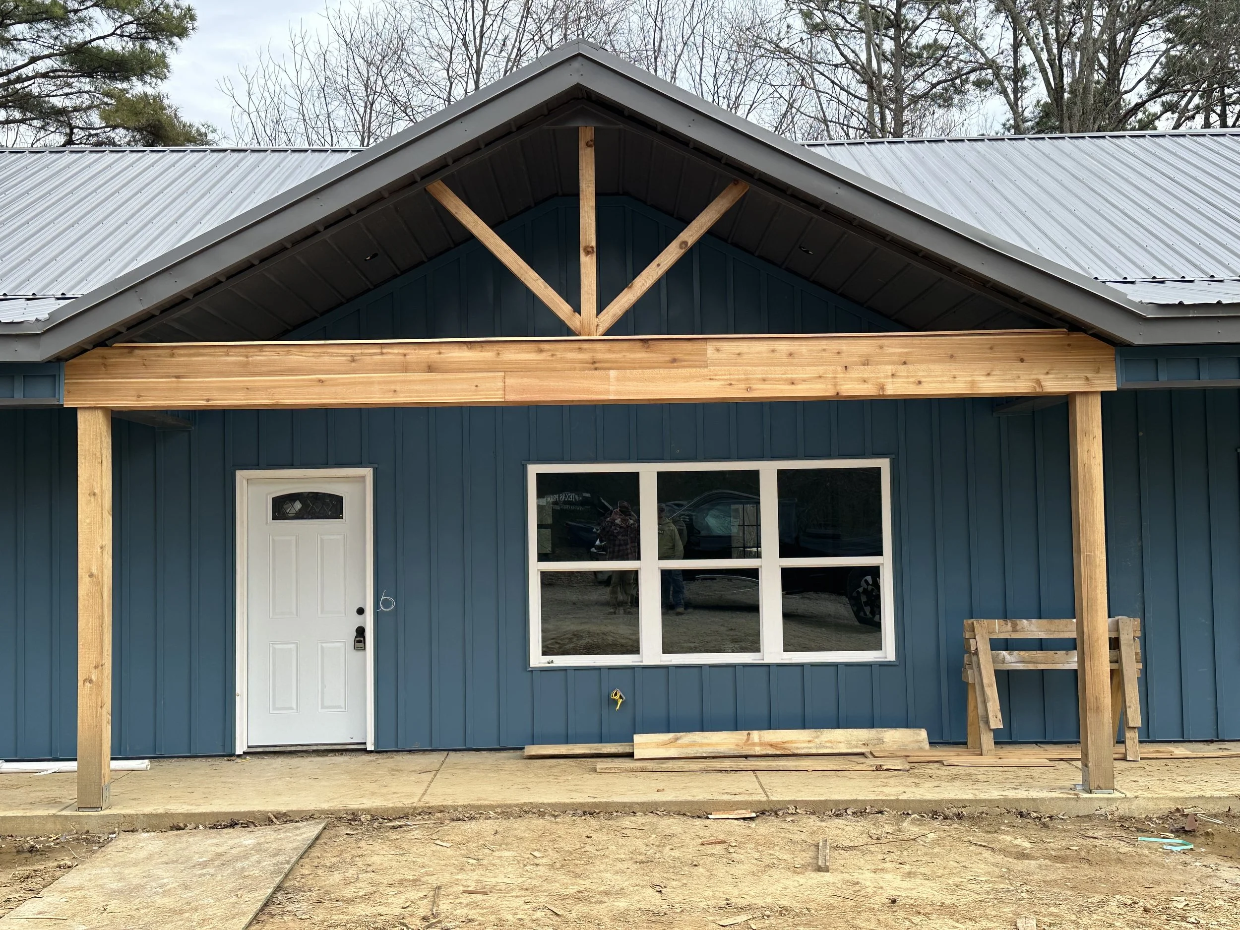 Floor plan and 3D exterior view of a small house with porch, living room, two bedrooms, kitchen, laundry, bathrooms, pantry, and closets.