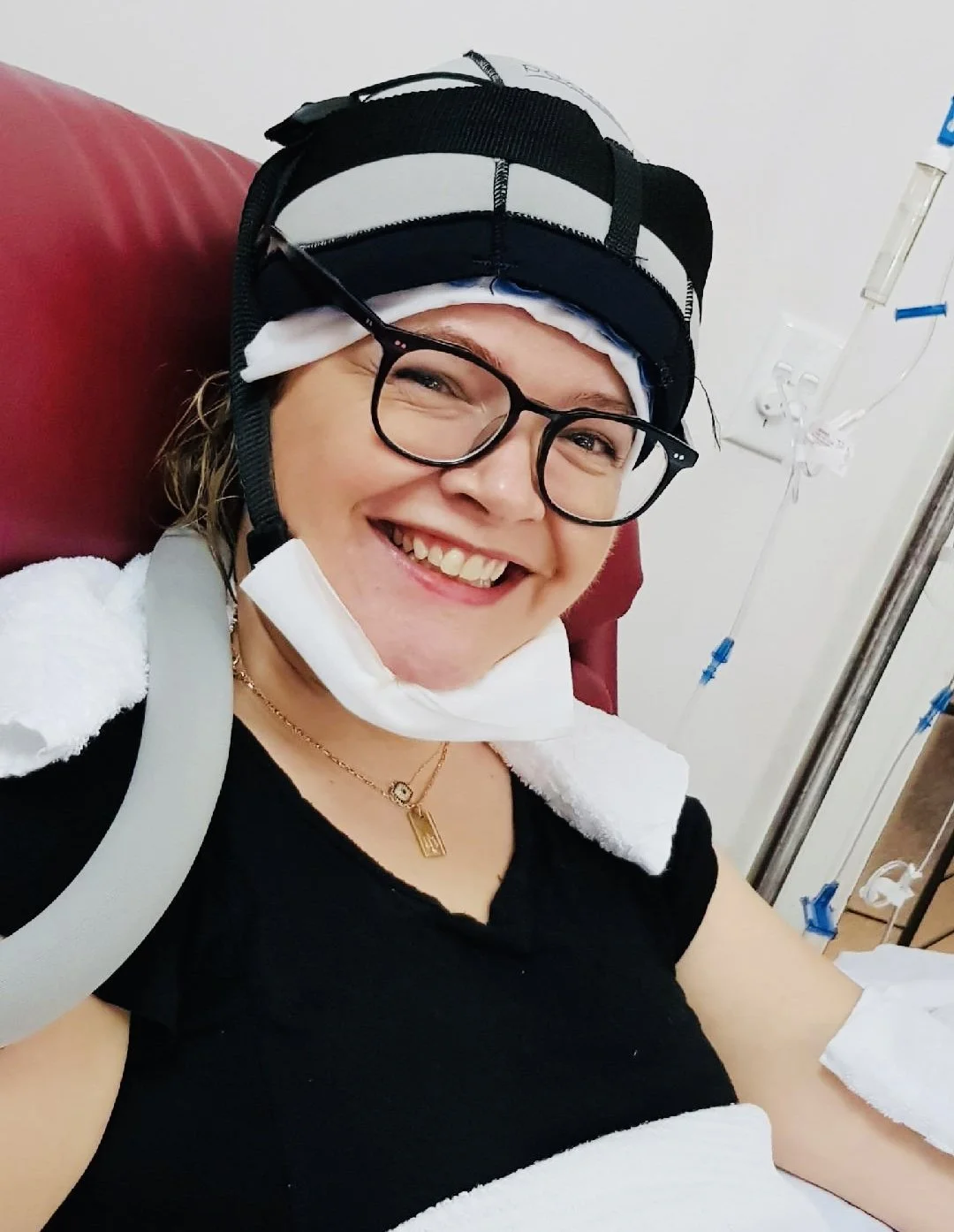 Luan Lawrenson-Woods smiling wearing a 'cold cap' while getting chemotherapy