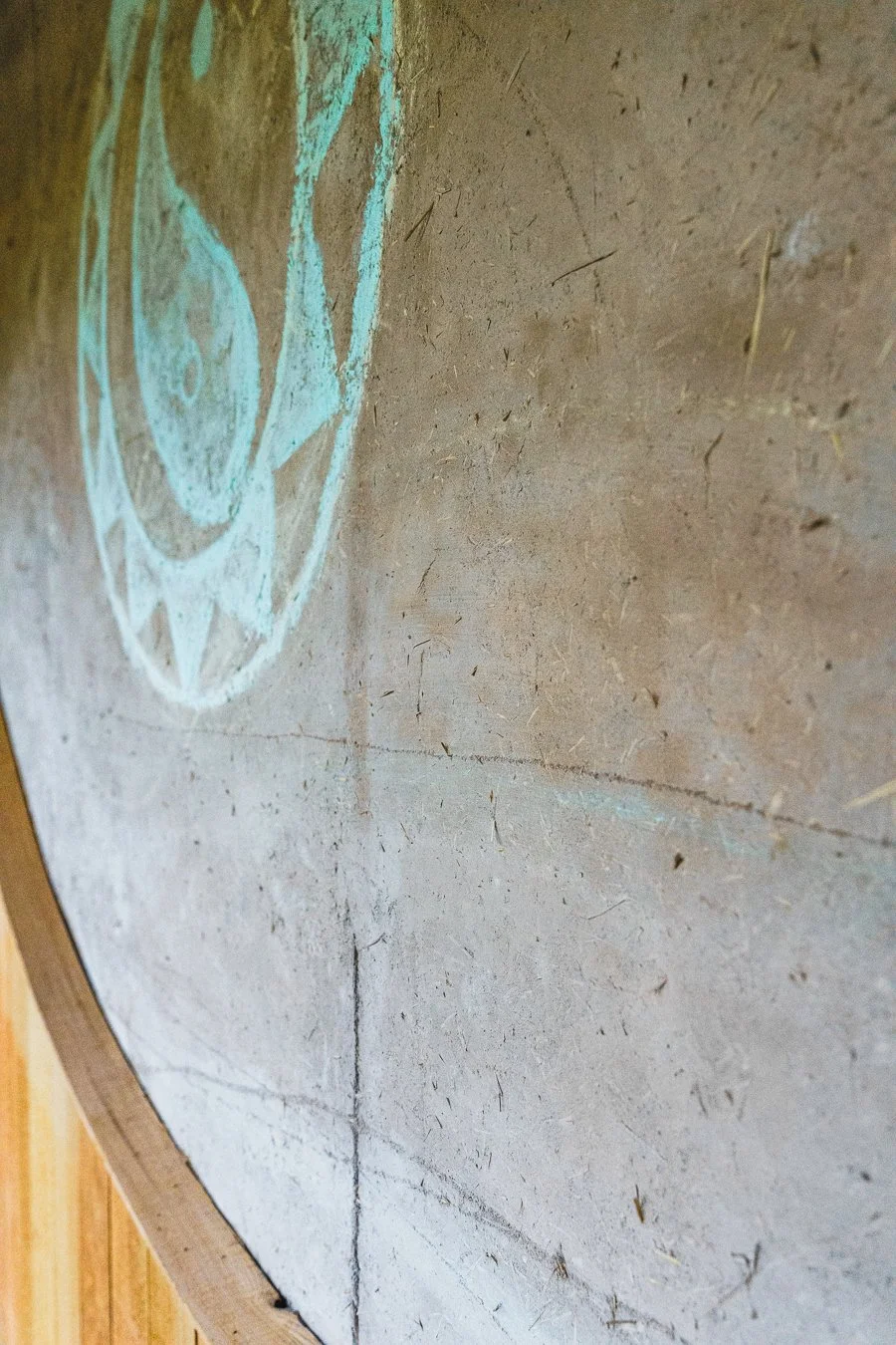 Concrete wall with a faint chalk drawing of a face, partially visible on the left side.