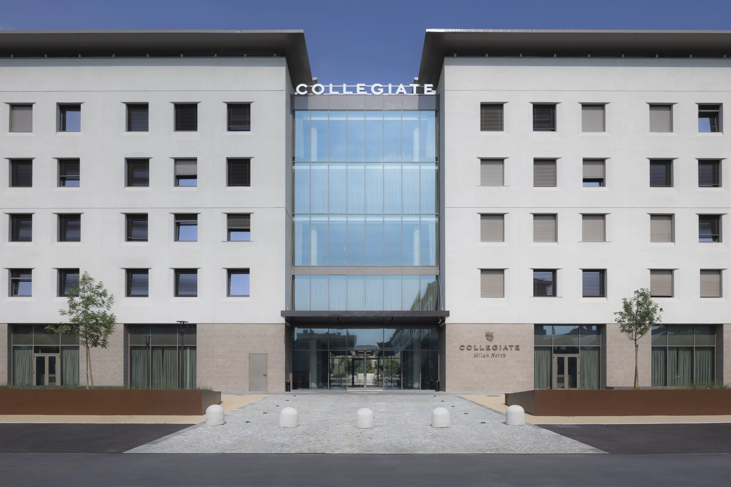 Facciata moderna di un edificio chiamato Collegiate, con un ingresso centrale in vetro e scritte sul lato destro e sopra l'entrata.