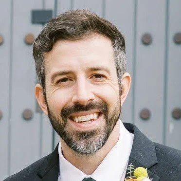 Man smiling in a suit with a boutonniere