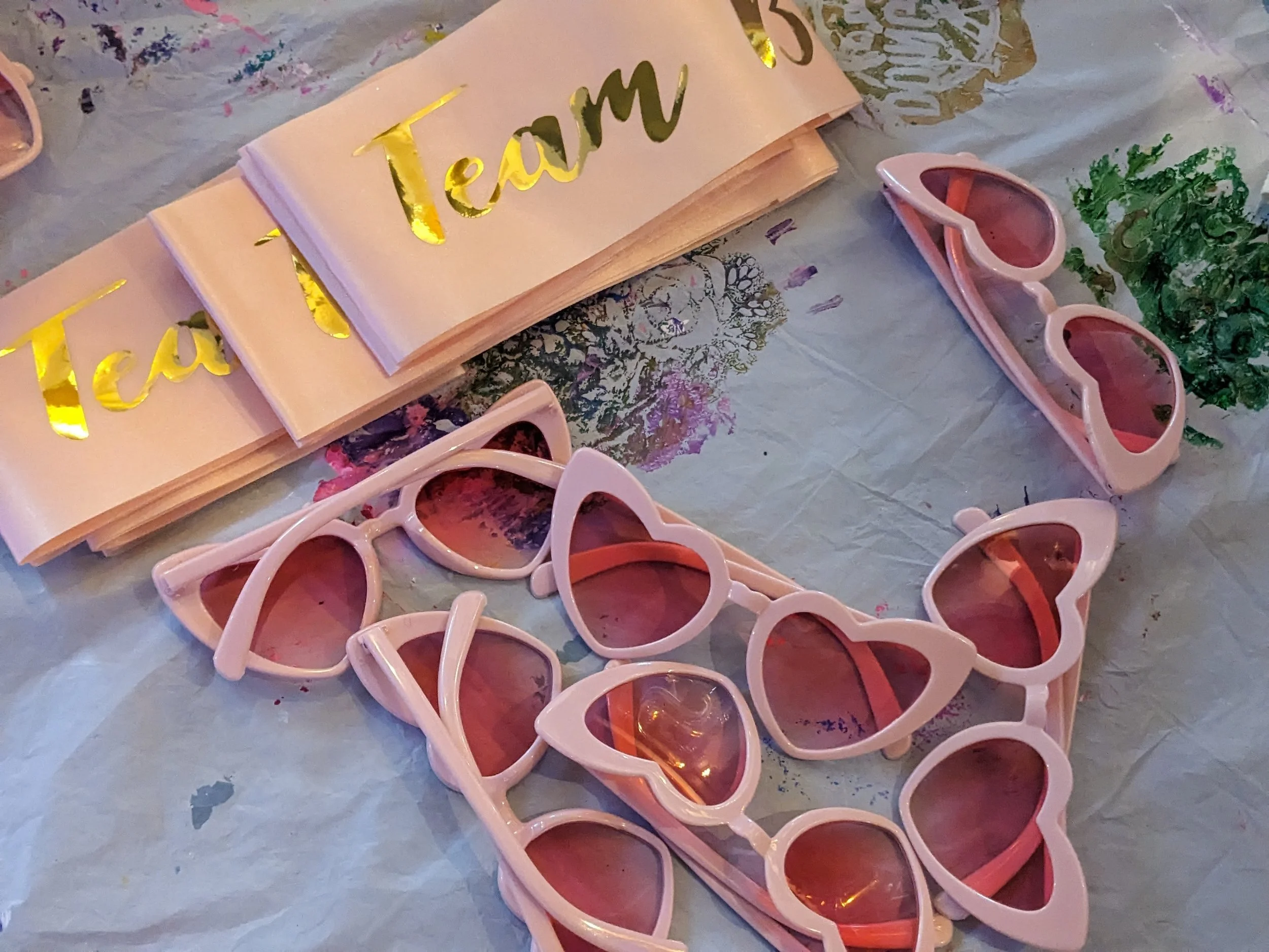Sonnenbrillen und Papptafeln mit goldener Aufschrift 'Team' auf einem Tisch