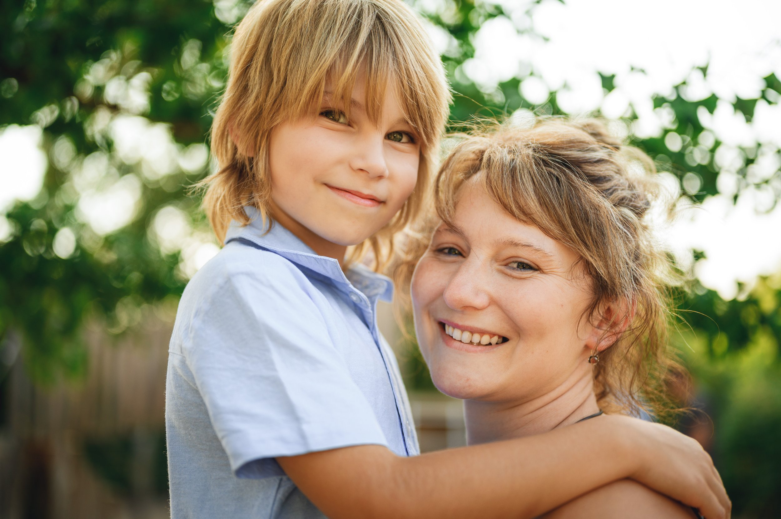 Mutter hält ihr Kind im Arm und beide lächeln in die Kamera – natürliches Mini Shooting Porträt in Südbrandenburg und Sachsen.