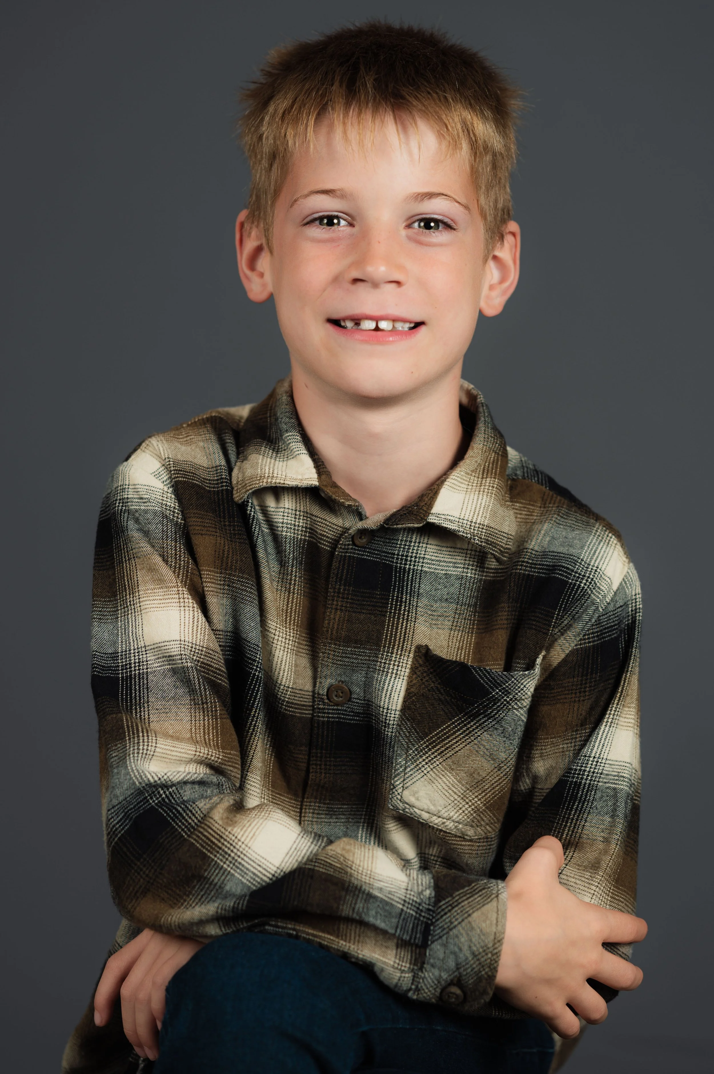 Modernes Schul-Studiofoto eines Schülers vor grauem Hintergrund.