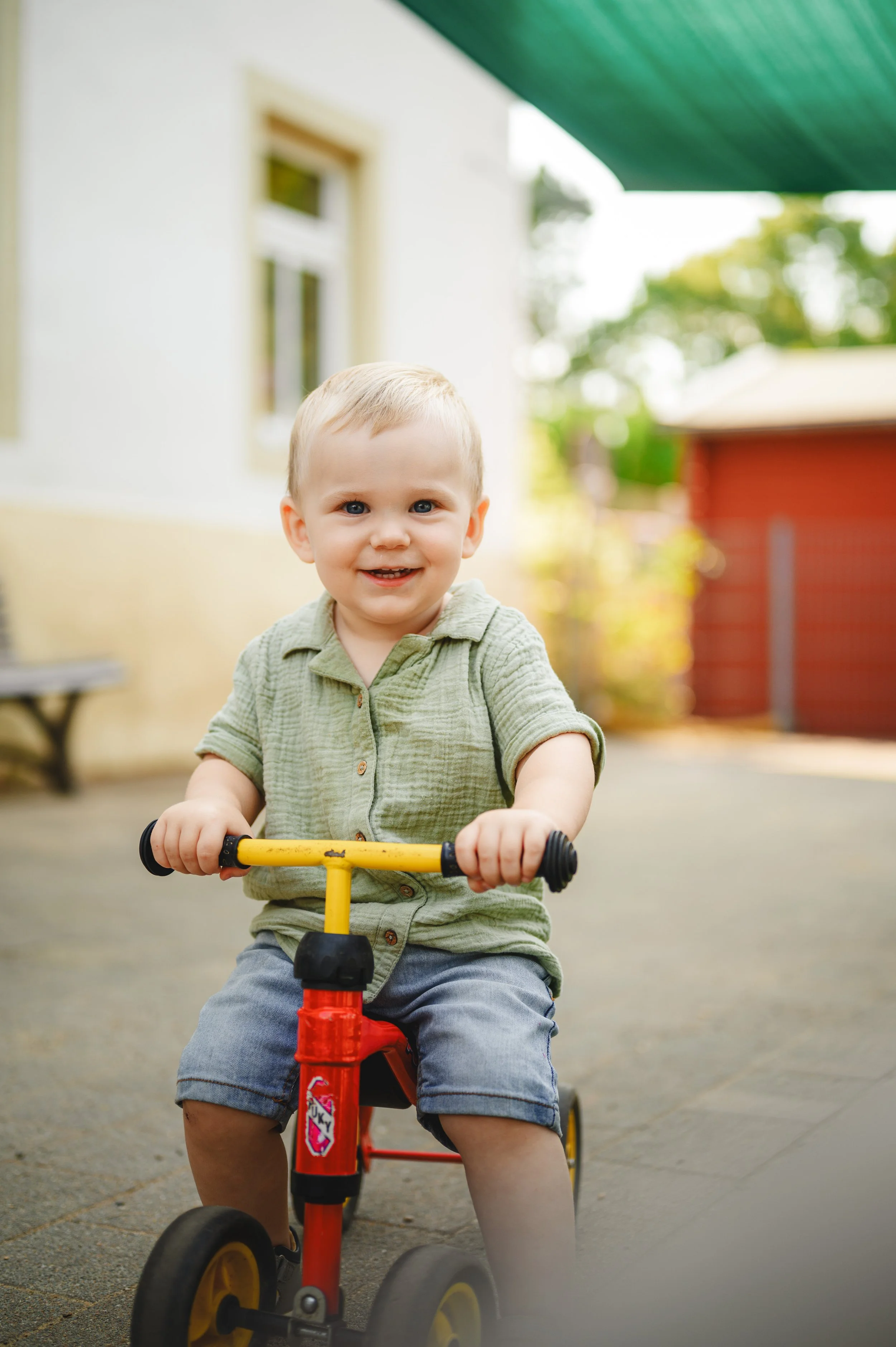 Natürliches Kita-Foto eines fröhlichen Krippenkindes beim Spielen im Außengelände – authentische Kinderfotografie in Brandenburg und Sachsen.