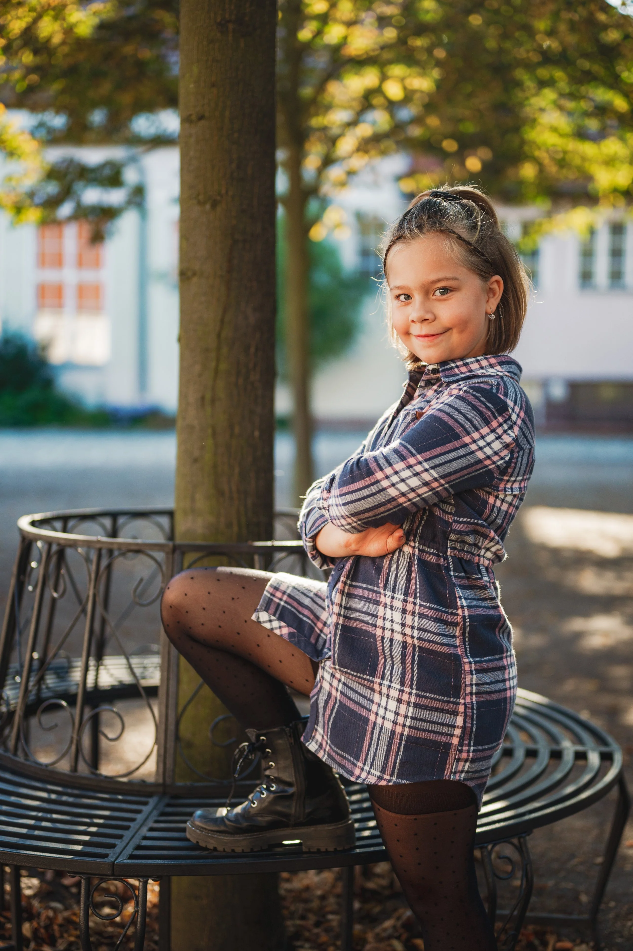Natürliches Outdoor-Schulfoto eines Grundschulkindes, fotografiert im Außenbereich mit weichem Licht und ruhigem Hintergrund. Ehrliche Ausstrahlung, entspannte Atmosphäre und ein zeitloser Look – moderne Schulfotografie ohne Zwang und ohne künstliche