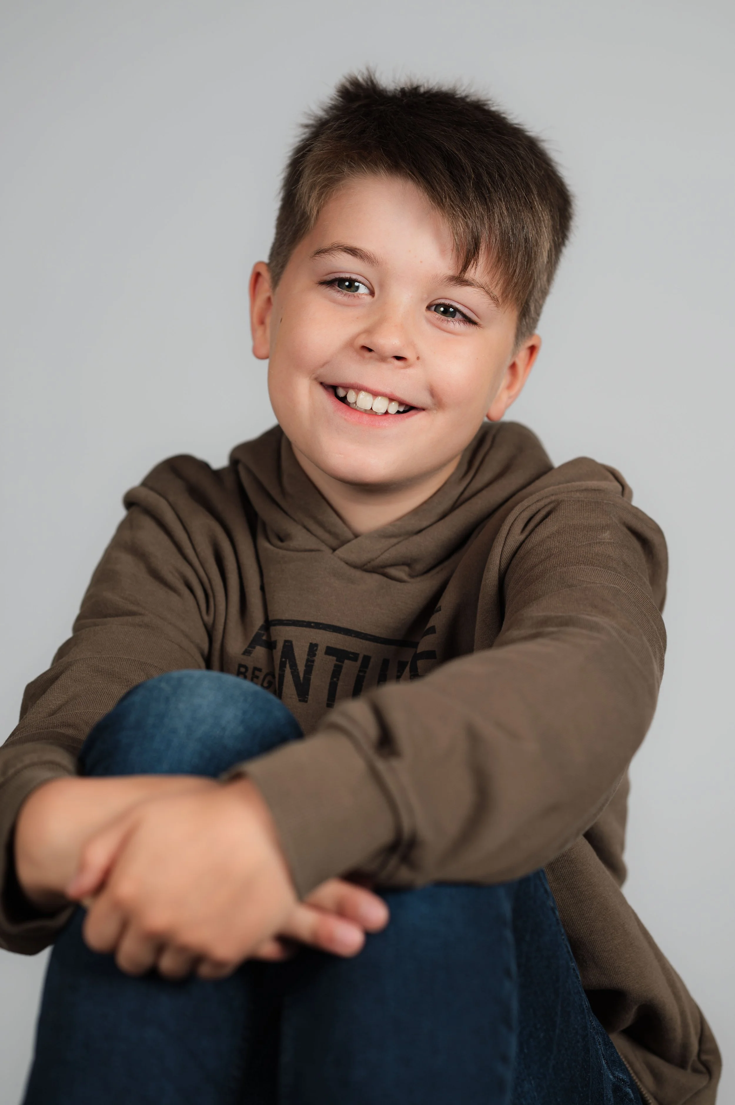 Zeitloses Studio-Porträt eines Schulkindes vor hellem Hintergrund – ruhige und moderne Schulfotografie.