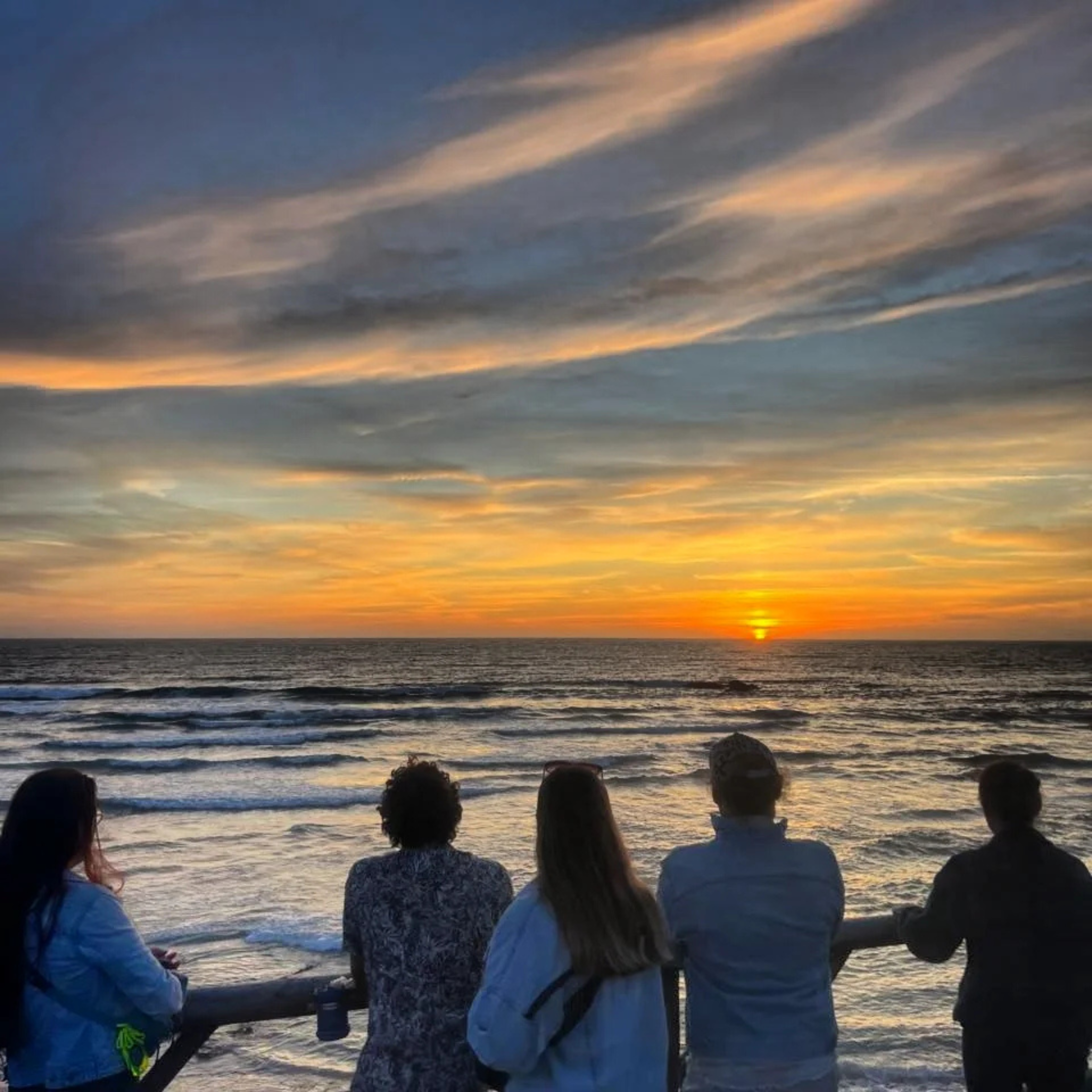 A Beyond Trails and Tales group watching the sunset by the beach