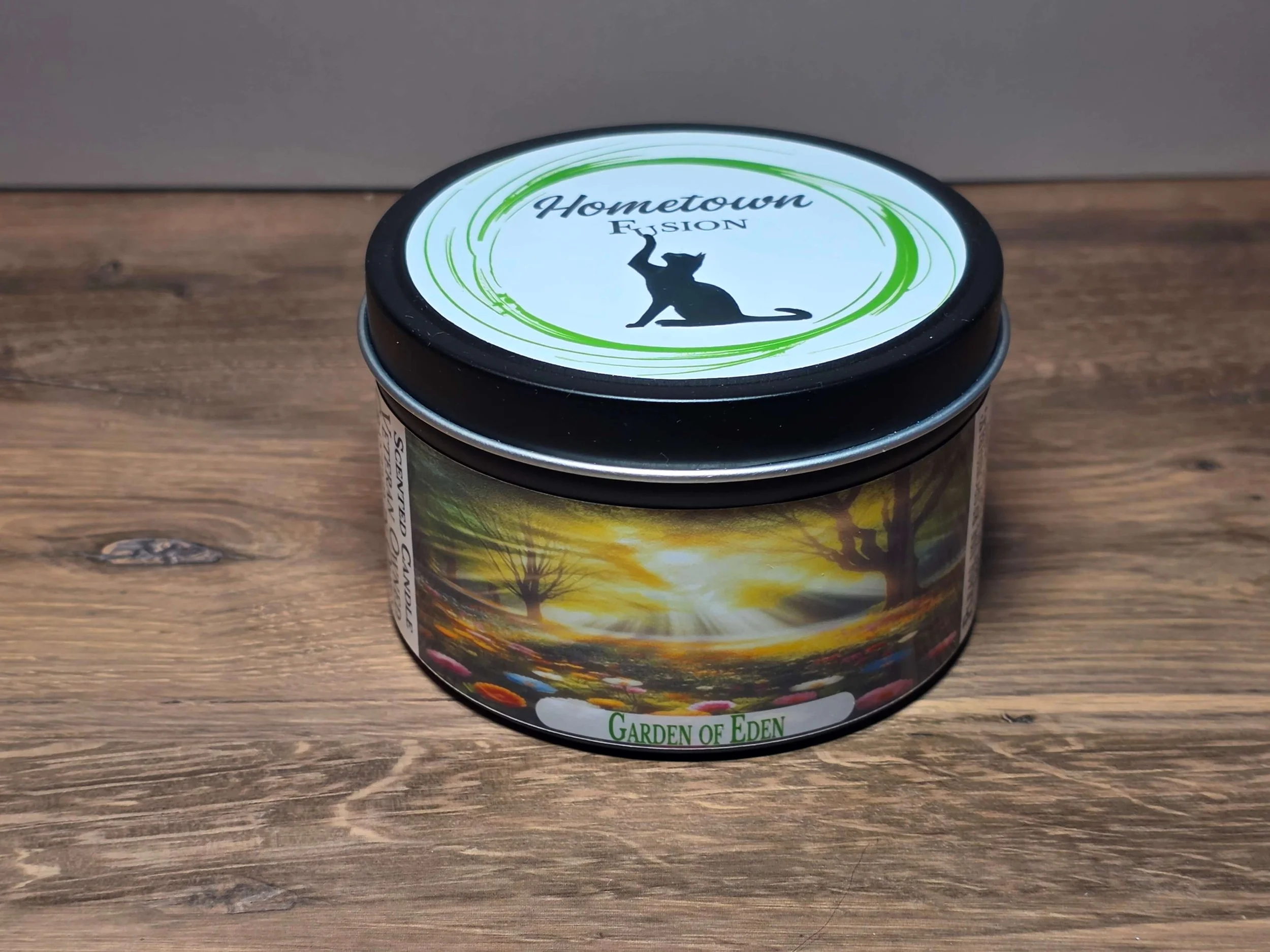 A round candle tin with a lid featuring Hometown Fusion's logo. Links to 6oz candle tins.