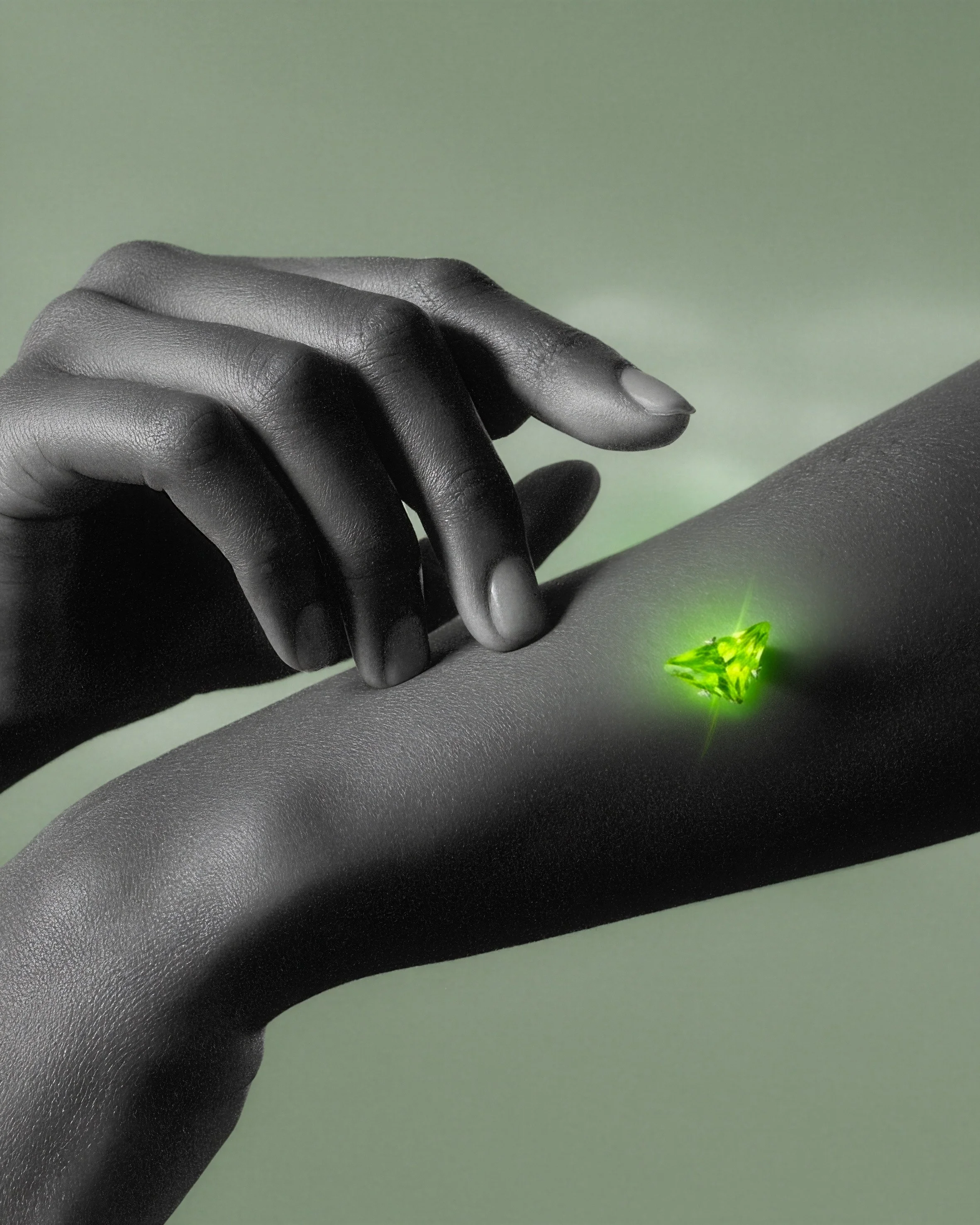 A hand with dark skin tone reaching towards a glowing green gemstone embedded in a surface.