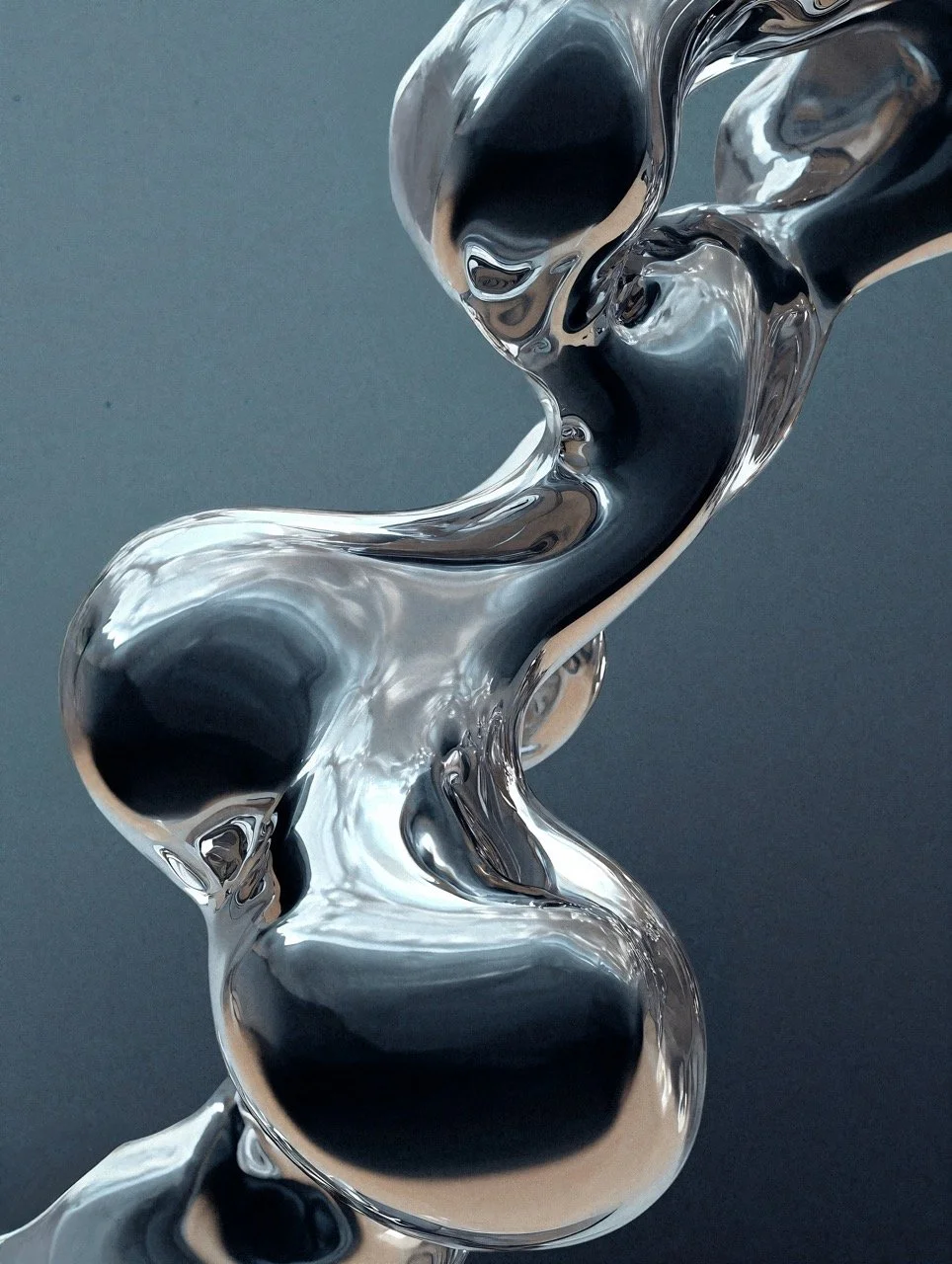 Close-up of a shiny, abstract metallic sculpture with smooth, flowing curves and dark reflections on its surface.
